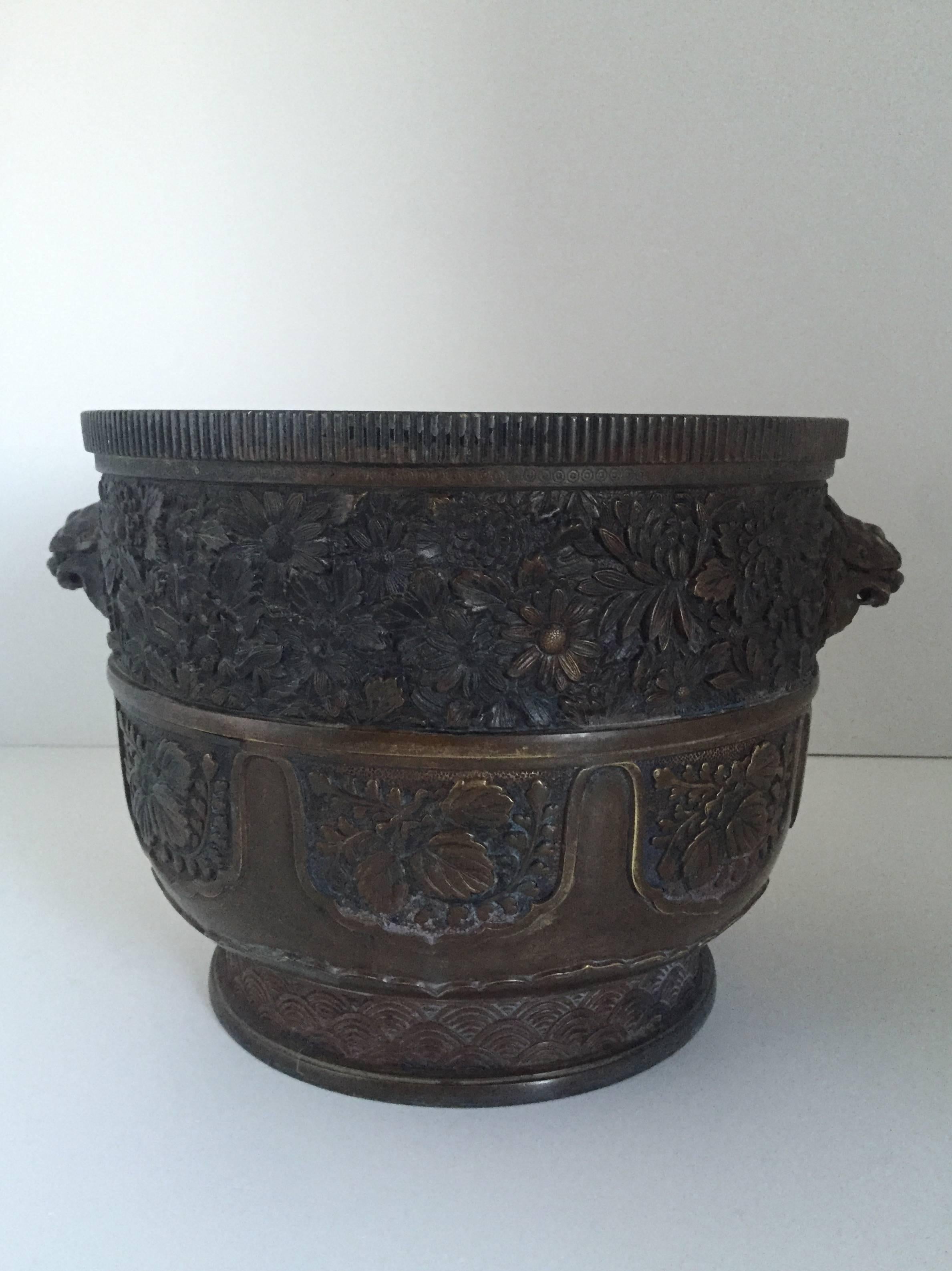 An extremely well cast large Chinese planter or jardinière, 19th century or earlier. There is a mark to the base which we haven't been able to read. The quality of the casting is fantastic and very accurate. The lion mascarons are expressfull and