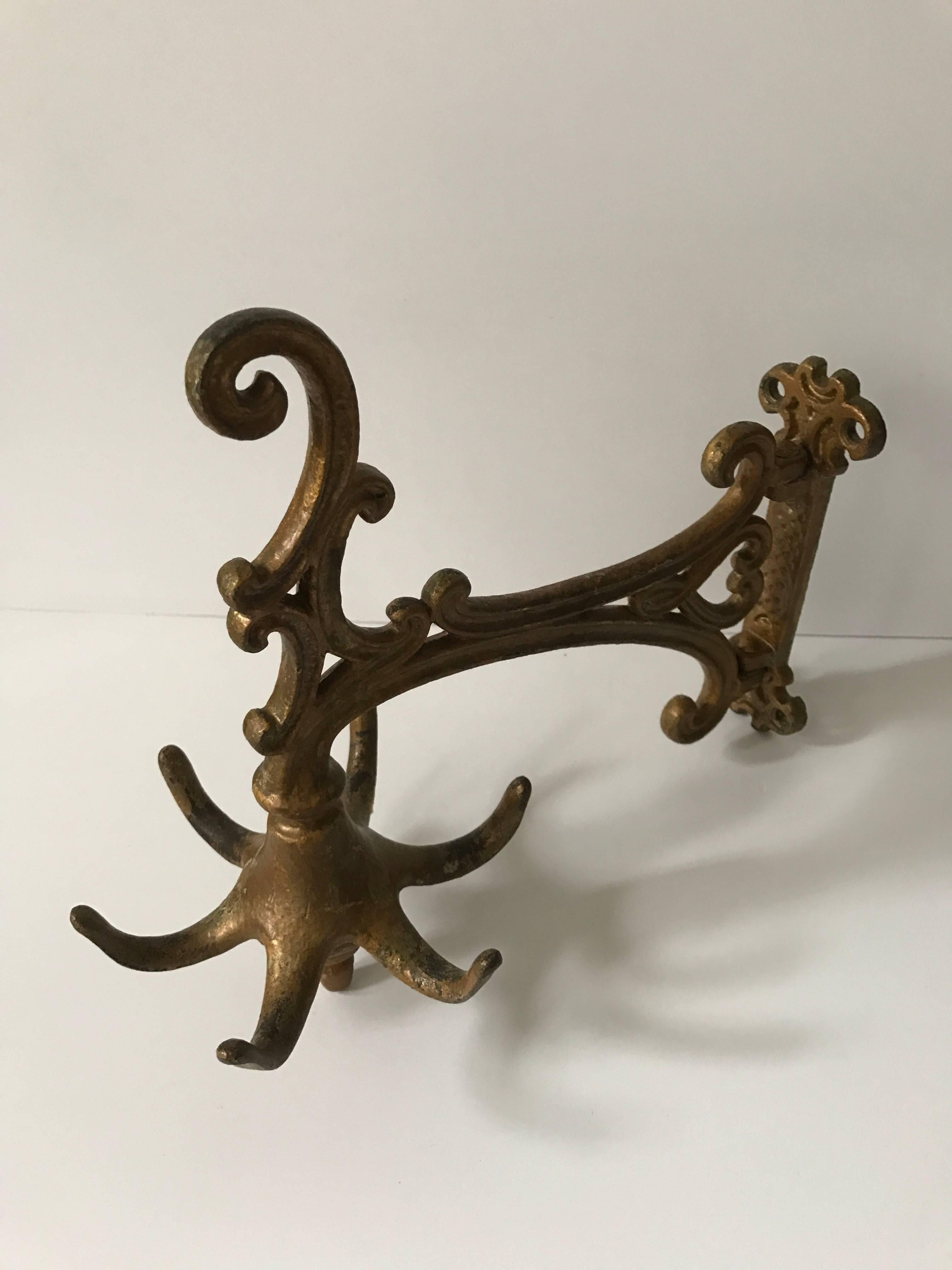 A beautiful coat hanger or coat rack that should be mounted to the wall. This was made during the late 19th century and is most likely Swedish. It is patinated as brass or bronze but is made of cast iron. It is 29cm in length and 25 cm in height and