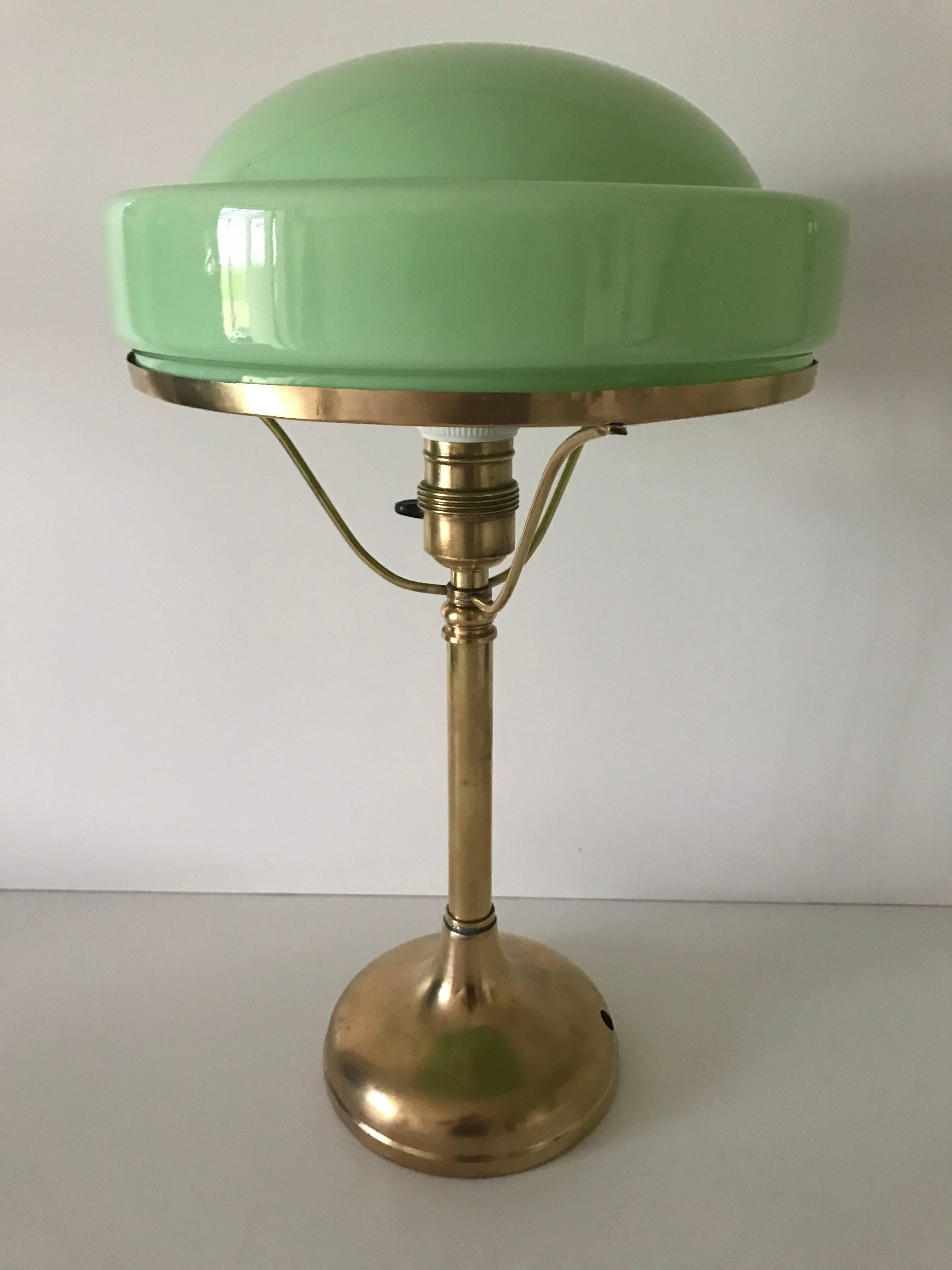 1920 Swedish Art Nouveau brass and glass table lamp by Böhlmarks.
A very nice brass table lamp most likely made at the Stockholm based Böhlmarks lamp factory and the glass shade made at Pukebergs glass factory.
The lamp is in a nice condition with