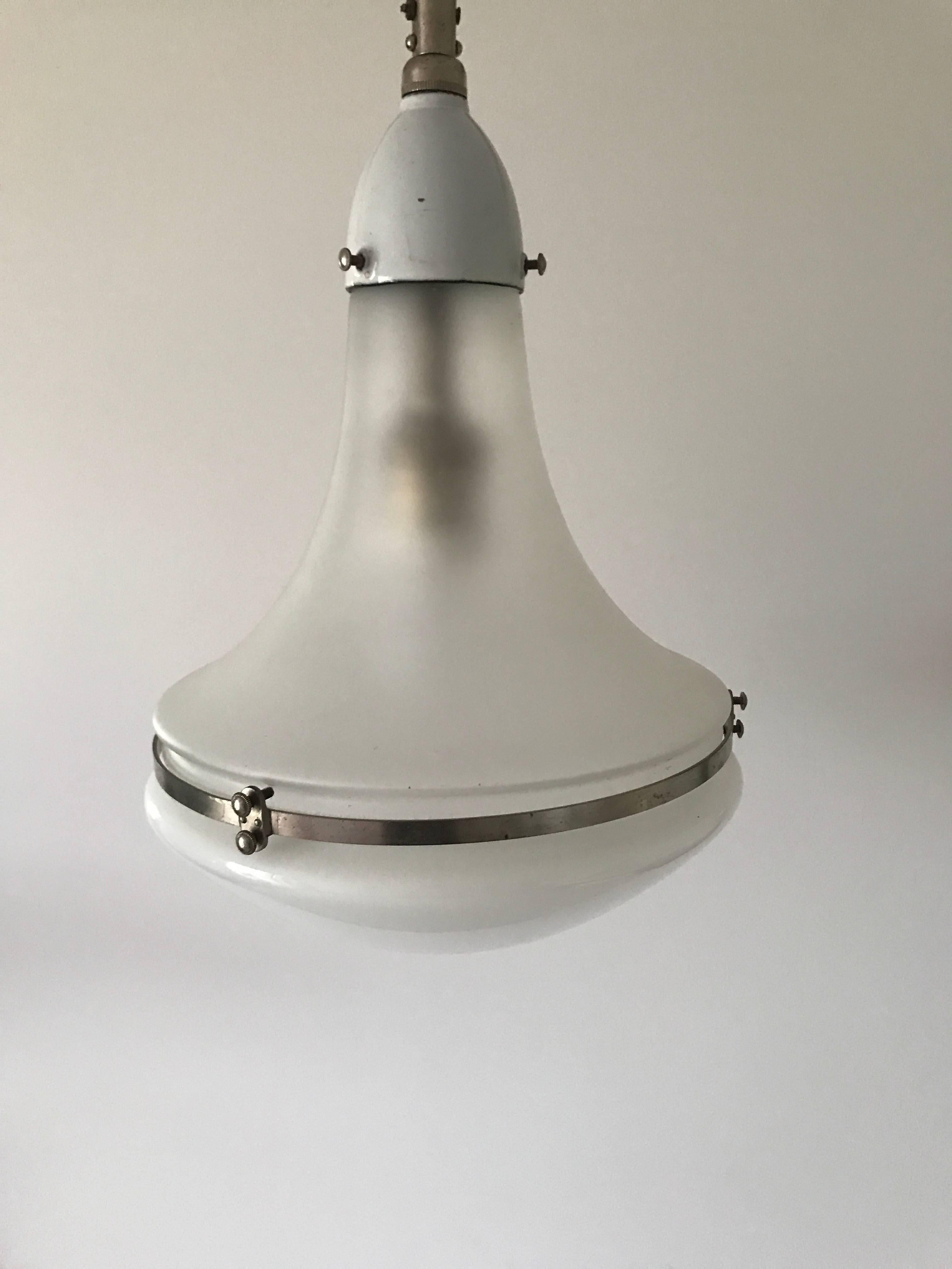 1925 rare white enamel Peter Behrens Luzette lamp small model.
This lamp is of the rare kind with white enamel on the tube and on the top mounts. The top of the shade is frosted and the bottom is opal white.
The lamp comes with new wiring and is