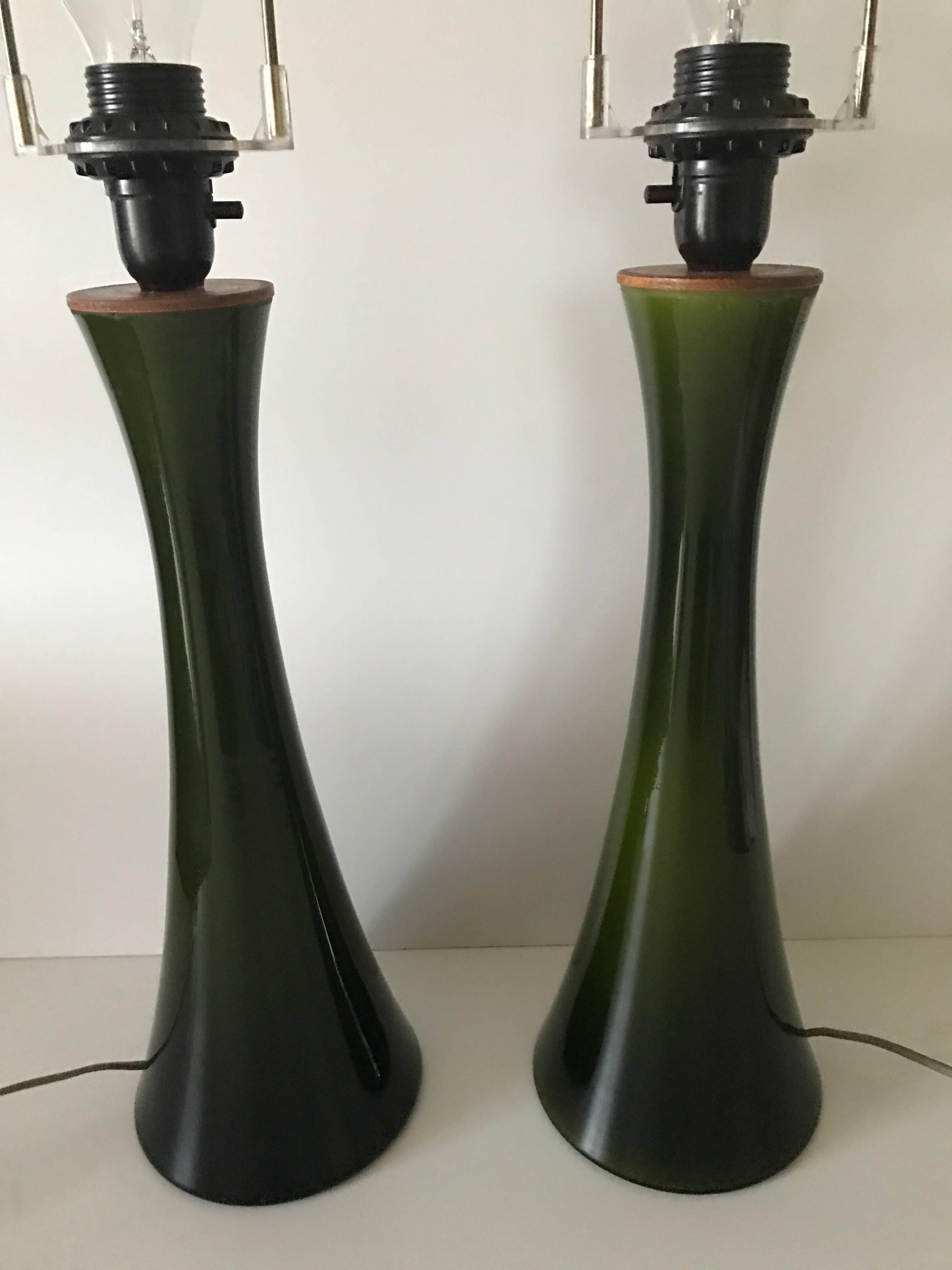 Pair of large 1950 Swedish Bergbom dark green glass and teakwood table lamps,
Beautiful and large table lamps, design by Bergboms but manufactured by Danish Holmegaard in the 1950s. The glass have a beatiful dark green colour, which is hard to