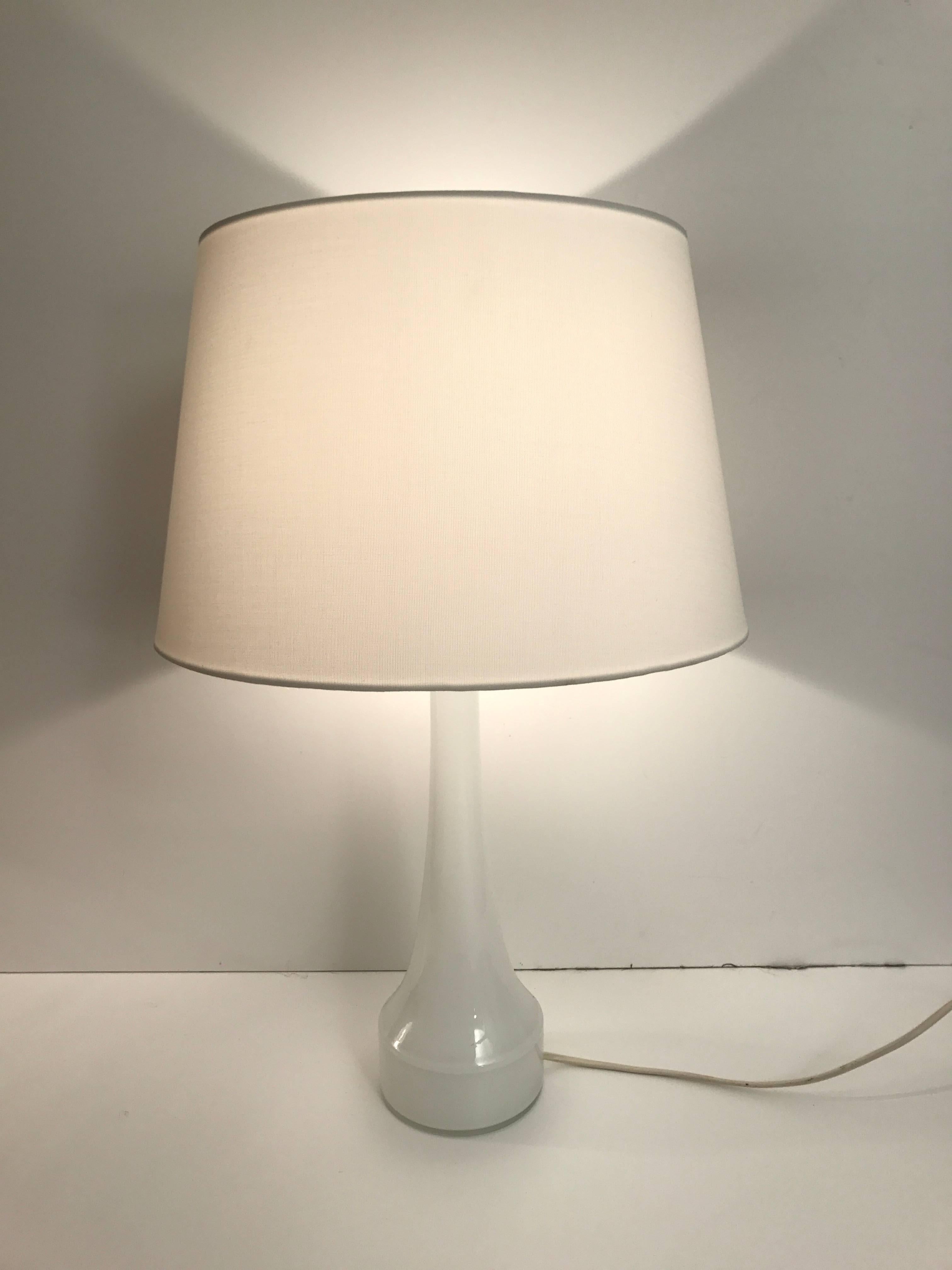Pair of 1955 white Bergboms/Holmegaard opaline glass table lamps.
Fantastic pair of white oplaine glass table lamps designed by Bergboms and manufactured by Holmegaard in Denmark. 
The pair is in a fantastic condition where new cords has been