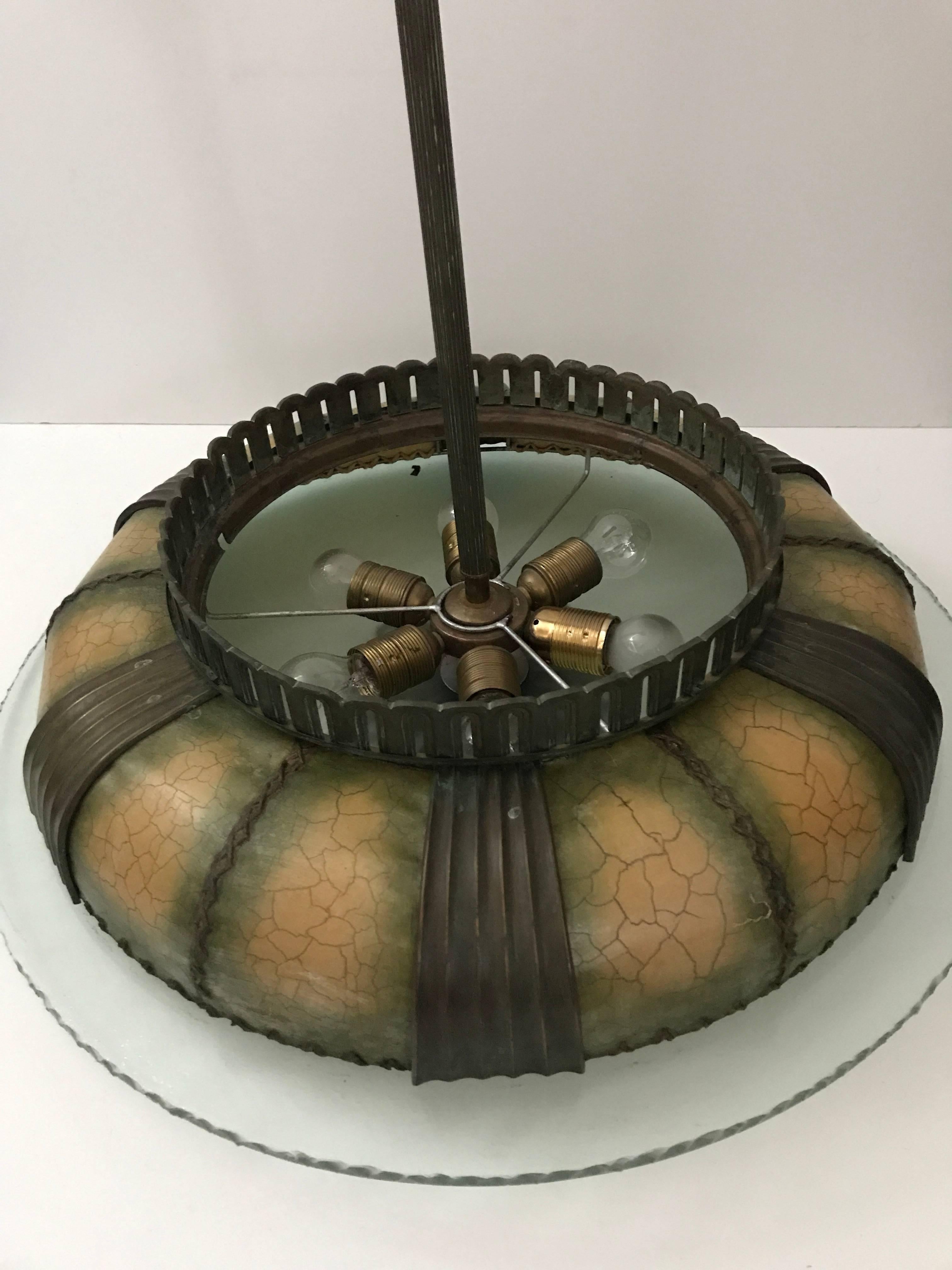 Large and rare 1930 Swedish Böhlmarks Art Deco glass and bronze pendant lamp
A fantastic pendant lamp made of a thick partly frosted glass shade with a hammered look, made by Orrefors and a top cover made of papier mâché and bronze details in a