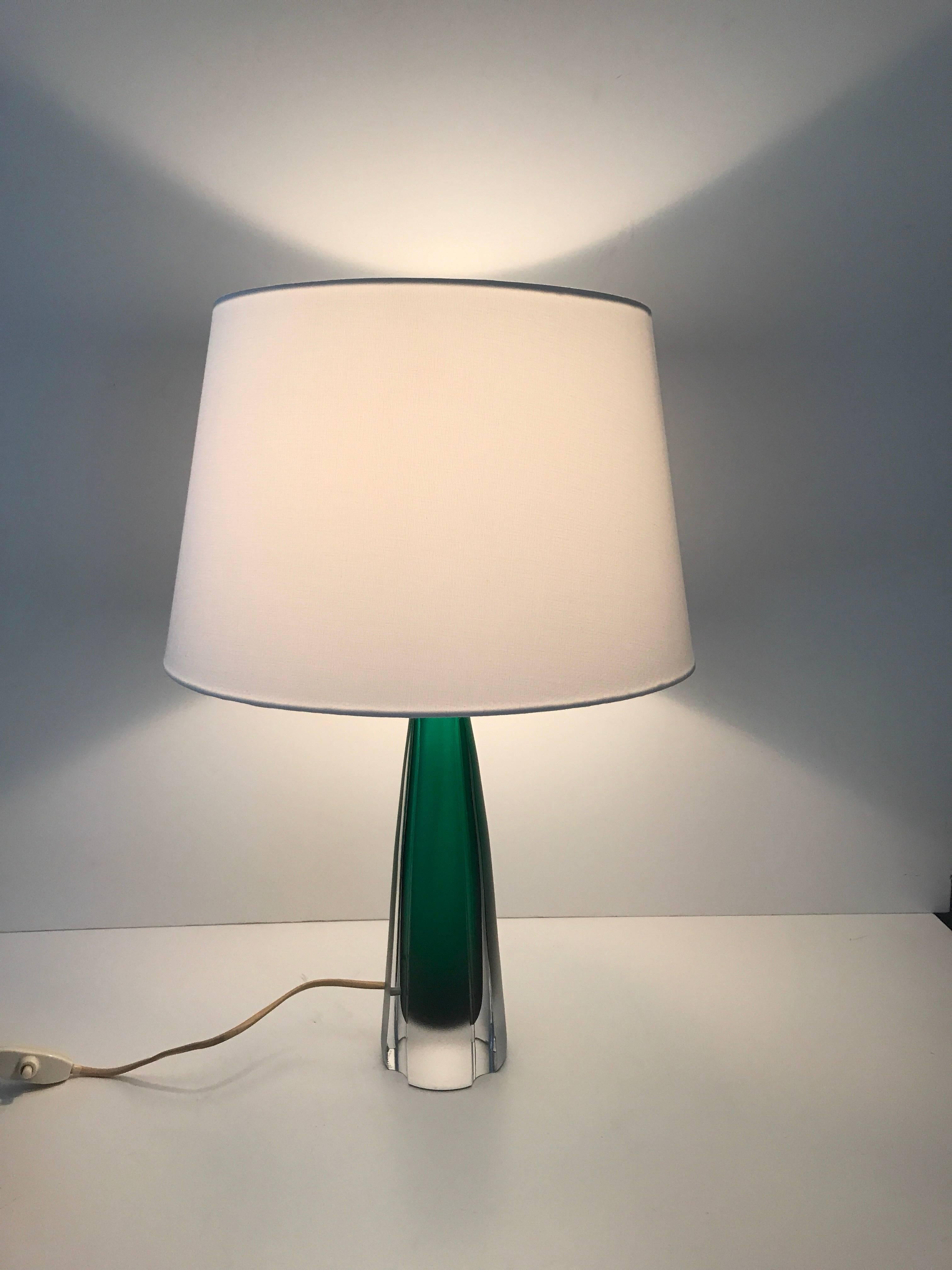 Swedish 1959, Kosta art glass table lamp. A beautiful Kosta art glass table lamp in a green underlay glass. The lamp has a beautiful intense green core that shows through the frosted, and partly cut-glass. It is marked Kosta Hx BA59, which tells us
