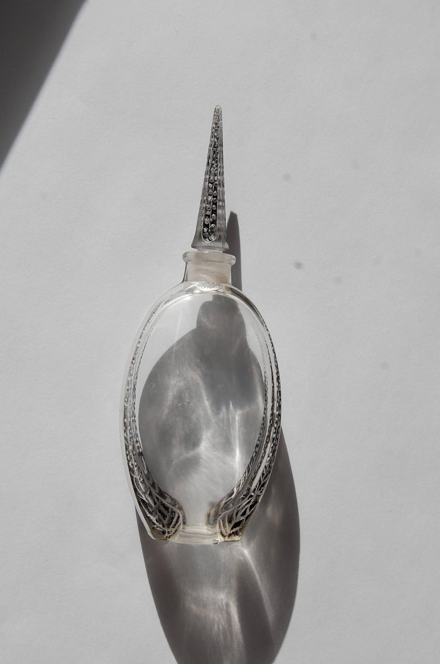 This complete perfume bottle for Lubin was designed by Rene Lalique (1860-1945) for the Christmas sales of 1920. It was one of the first monumental designs Lalique made in glass. The bottle is in very good original condition with grey staining. The