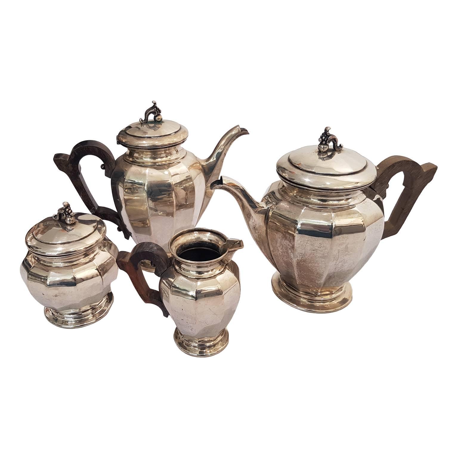 Set composed by teapot, coffee pot, milk jug and sugar bowl with wooden handle and hinged lids with cornucopia knobs.

Produced by Bolli, Milan, by the famous silversmith Enrico Messulam.

Measures: Teapot: 20 x 12 x 23 cm
Coffeepot: 21 x 11 x 22