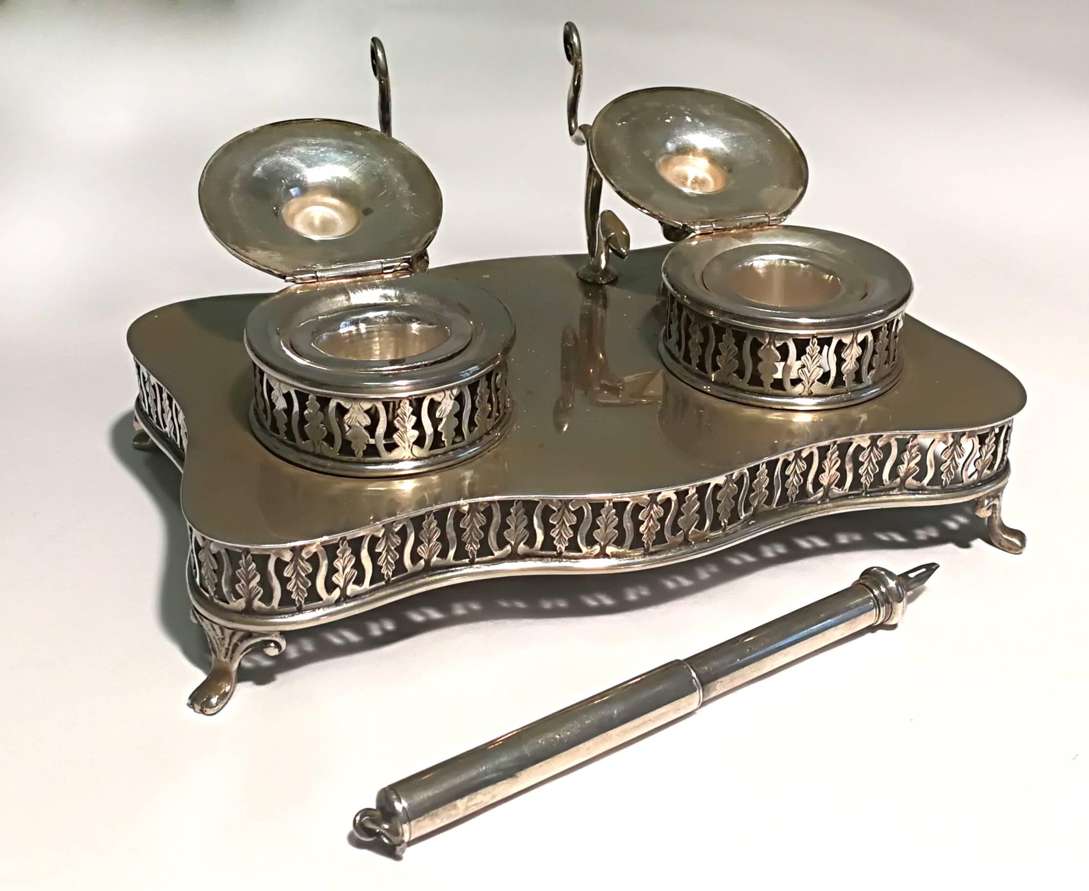 Silver inkwell with two flacons in smooth silver with perforated decorations, four wavy feet and a silver pen. 