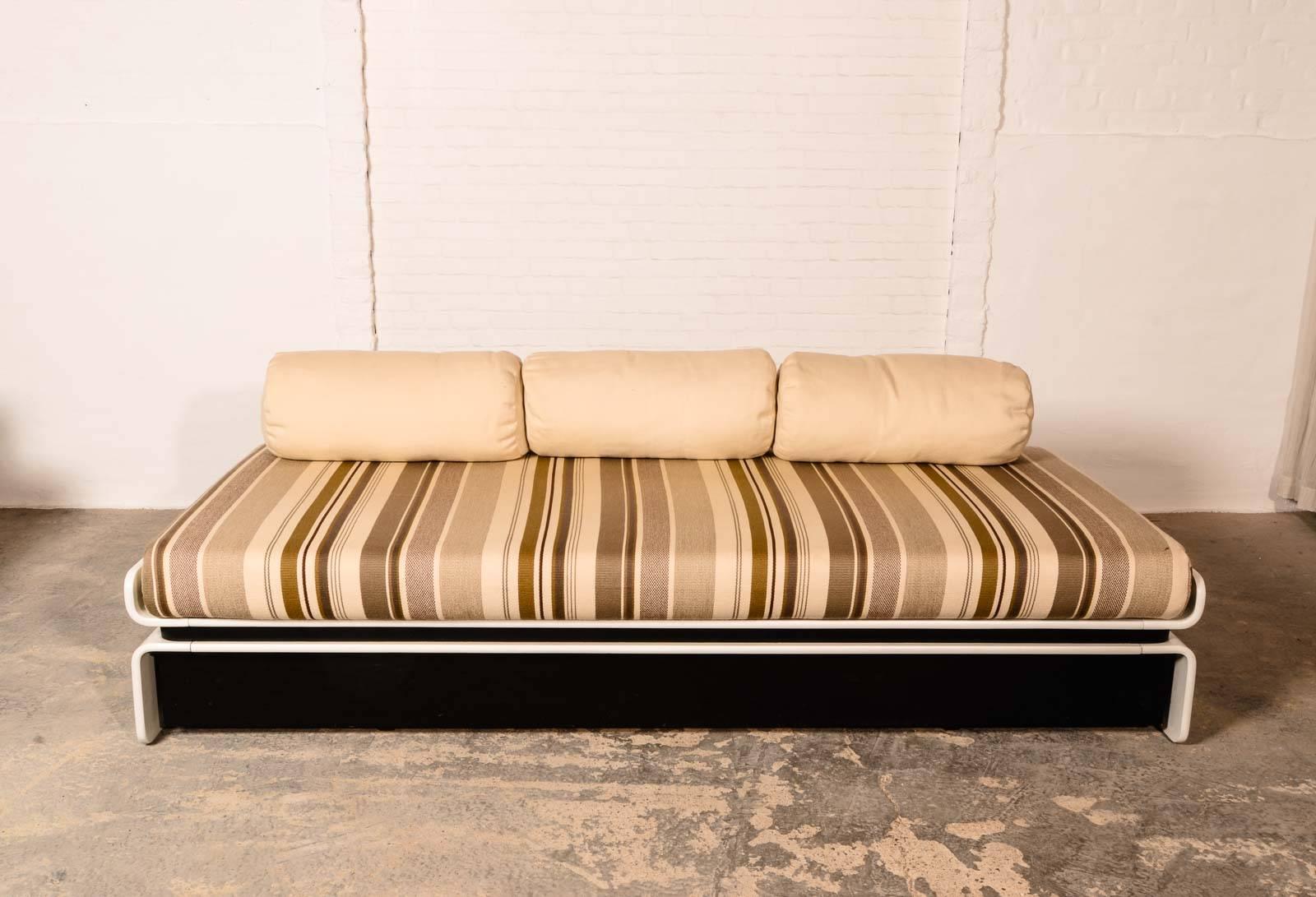 Mid-Century daybed with cushions designed by Luigi Colani for COR. This daybed is made of creamy colored lacquered wood and upholstered with a striped brown and olive green fabric. It contains also the original black covered mobile drawer. The