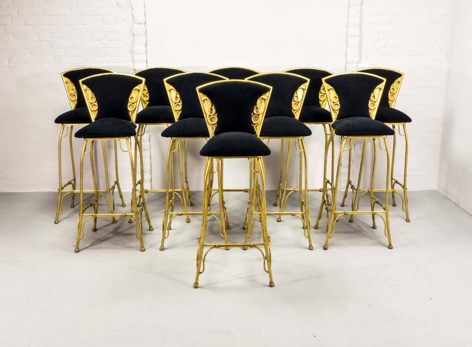 Beautiful set of ten gilded cobra barstools upholstered in black fabric. The forged and gilded frames show great craftsmanship and the golden cobras are nicely sculptured on the front and backside of the backrest. These very well preserved and