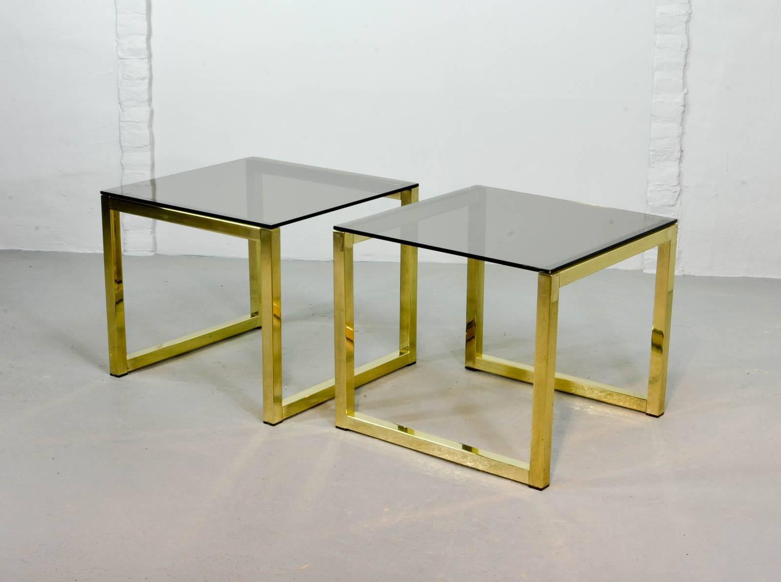 Pair of gold gilded chrome cubic tables with a thick smokey glass top. Manufactured in the 1980’s.
Can be used either as side tables or coffee tables. Fits very well in a Hollywood Regency oriented interior. The set is very well preserved with only