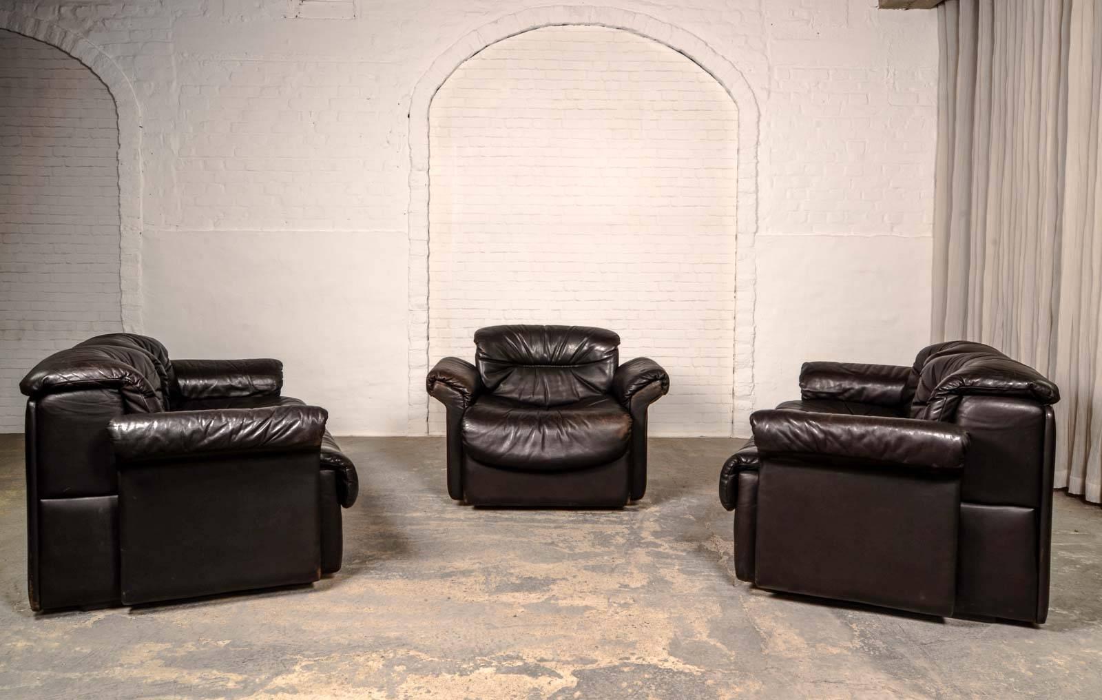 Exclusive set of two rare modernistic leather sofas and lounge chair beautifully designed in the eighties for De Sede. Executed in a deep fine blackish brown leather upholstery with subtle leather lace details. This Swiss design seating group is in