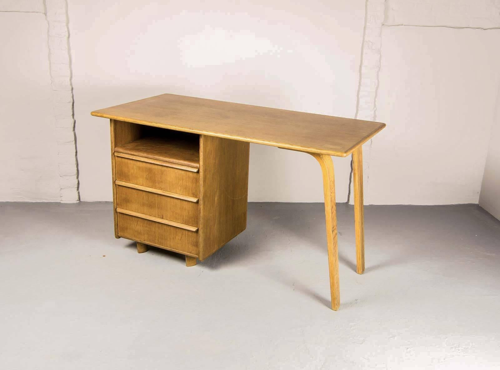 This Dutch design 'EE02' desk from the oak series was designed by Cees Braakman in 1948 and produced by Pastoe, The Netherlands. It is made from oak and has plywood legs. It contains three anti-dust drawers and a shelf on the left. The working