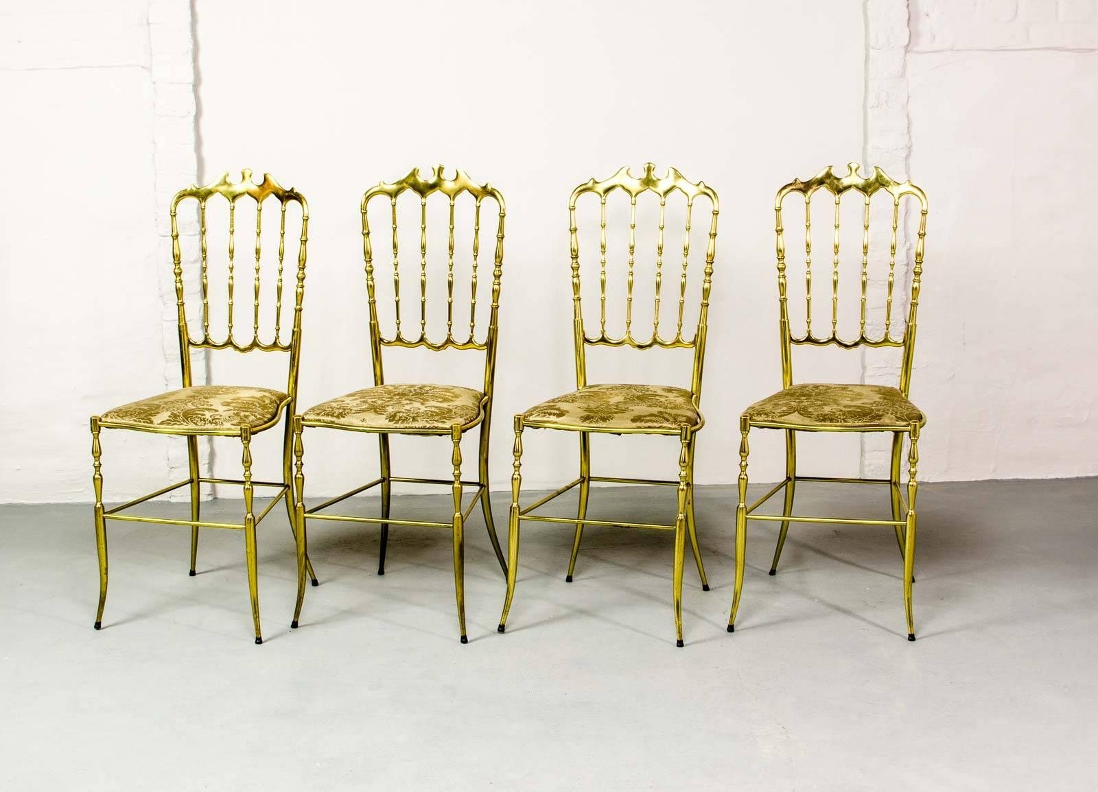 Set of four Mid-Century Italian brass Chiavari spindle back chairs with padded seats upholstered in golden gobelin fabric. These polished brass chairs are designed by Giuseppe Gaetano Descalzi for Chiavari, named after the Italian city where they