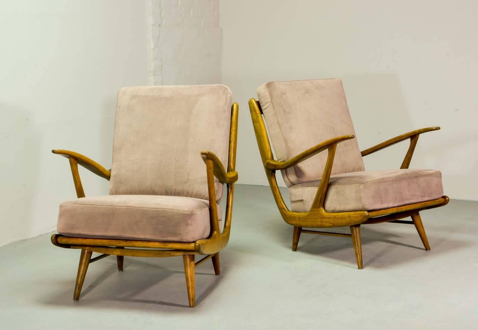 Art-Deco influenced Mid-Century set of lounge chairs with new mink colored velvet upholstery. The elegant organic shaped frame with spindle back is made of massive walnut wood. These very comfortable high quality chairs of the 1950s reminds of the