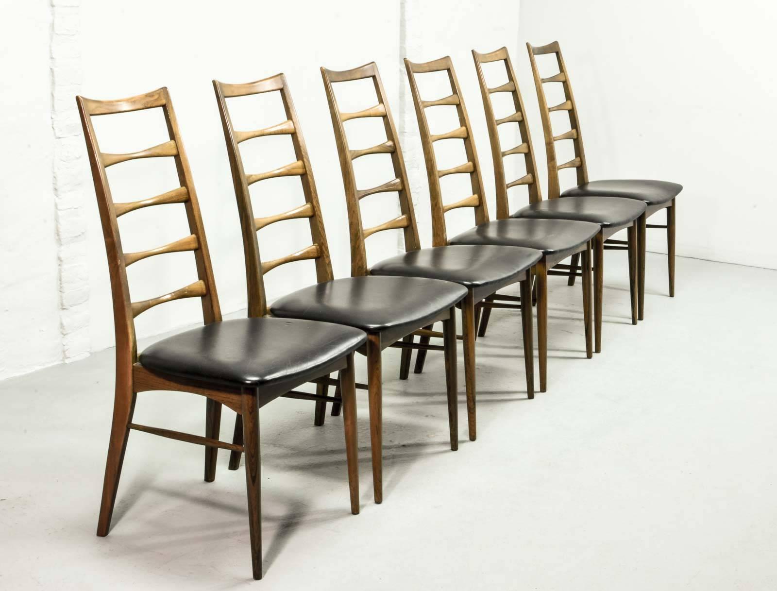 Sublime rosewood set of six high back dining chairs designed by Niels Koefoed for Koefoed Hornslet, Denmark. This stylish and elegant model ‘Lis’ with uniquely tapered ladder back and legs has its seat pad upholstered in a perfect conserved black