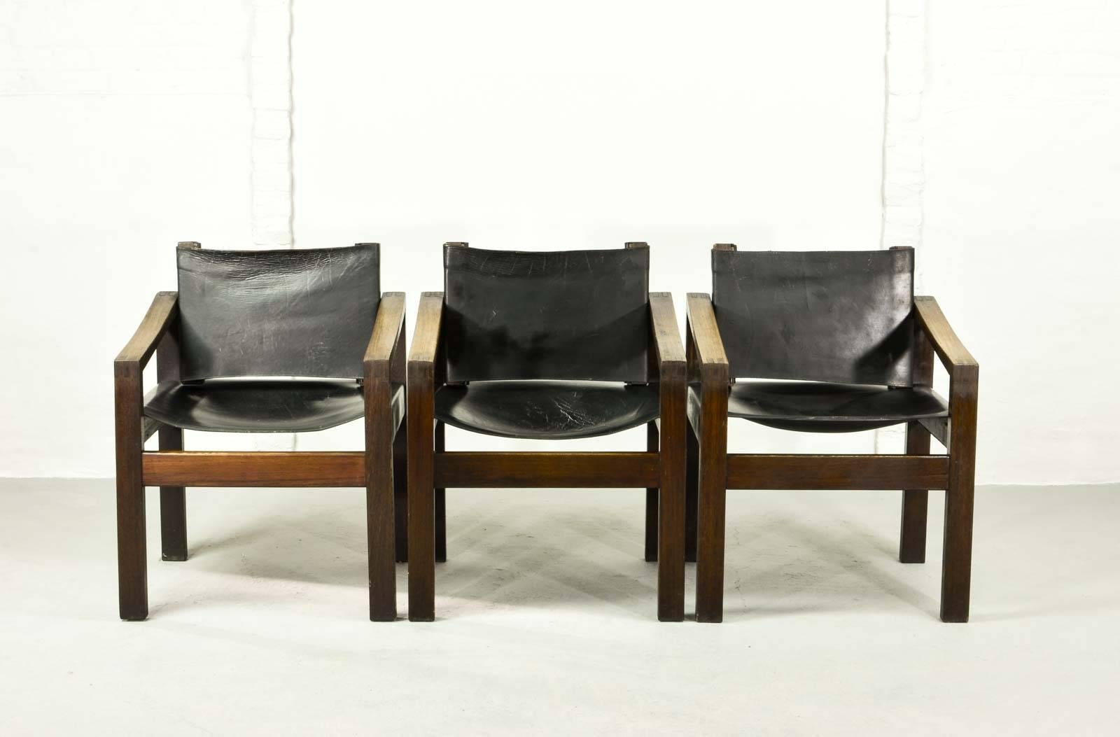 A set of three Spartan designed chairs from unknown origin, but beautiful in its simplicity and craftsmanship. The set features a cubic solid wengé wooden frame with sturdy saddle leather seating and backrest.
 