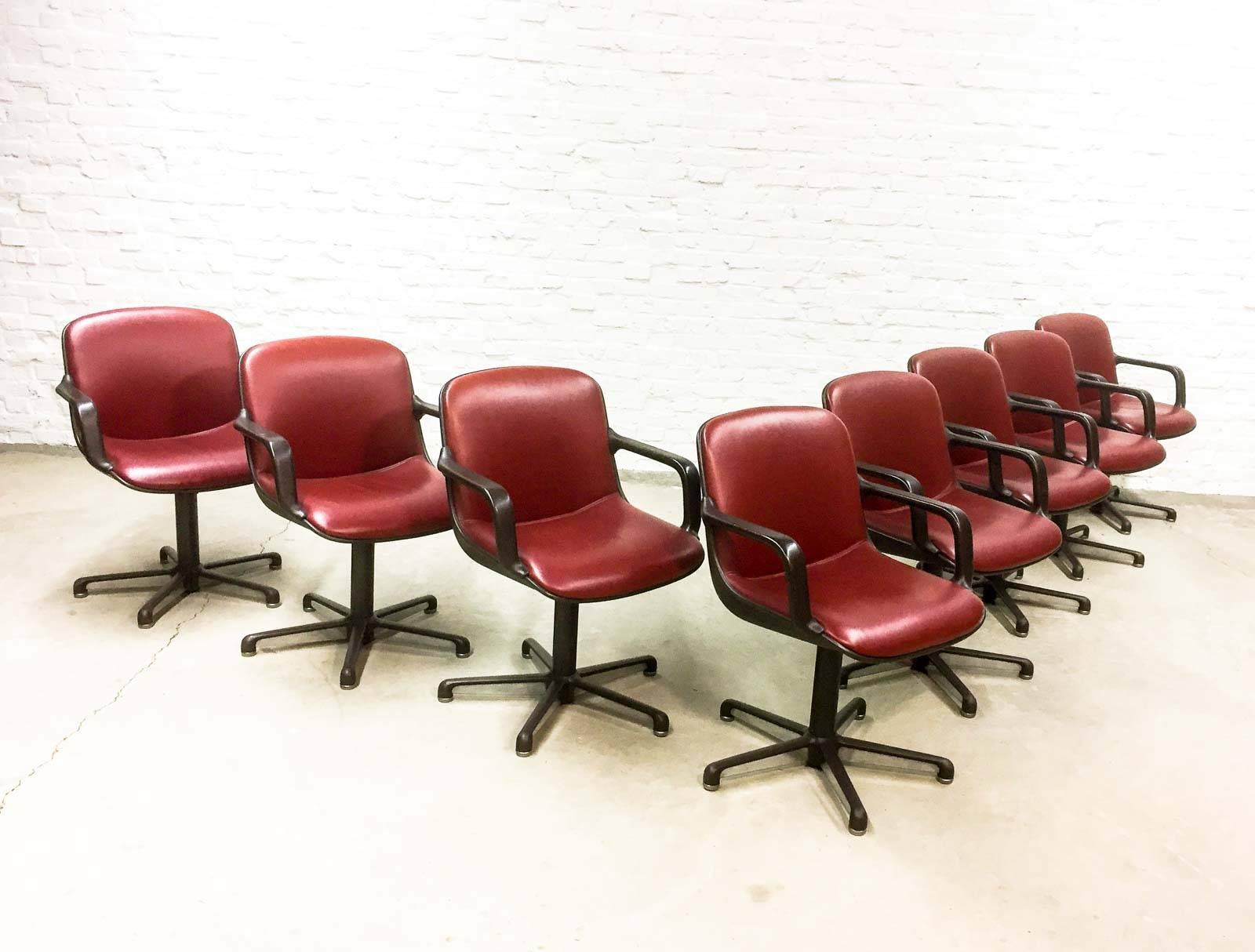 Sublime set of eight high quality modern office, desk or dining chairs designed in the style of Charles Pollock and manufactured by Comforto, Italy in the 1980s. The set features a hard plastic black shell with burgundy red leather upholstery, a