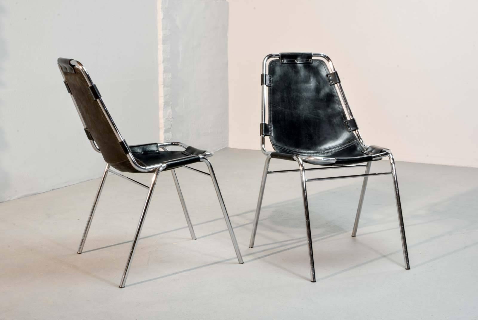 A pair of authentic Les Arcs chairs, designed by the French furniture maker Charlotte Perriand for Ski resort Les Arcs, France, 1968. Exclusively manufactured by the renowned Italian furniture maker Cassina. This rare black early edition shows a