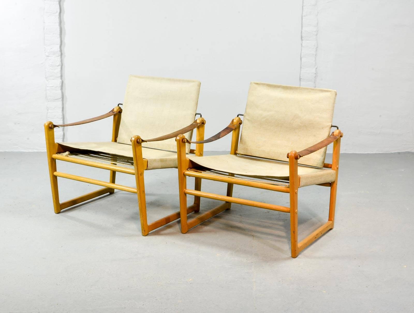 Midcentury Swedish pair of safari chairs designed by Bengt Ruda for Ikea in the 1960s. The beech wooden frame is upholstered with a canvas seat and backrest and features nice thick leather arm rests. The set is very well preserved with minor wear