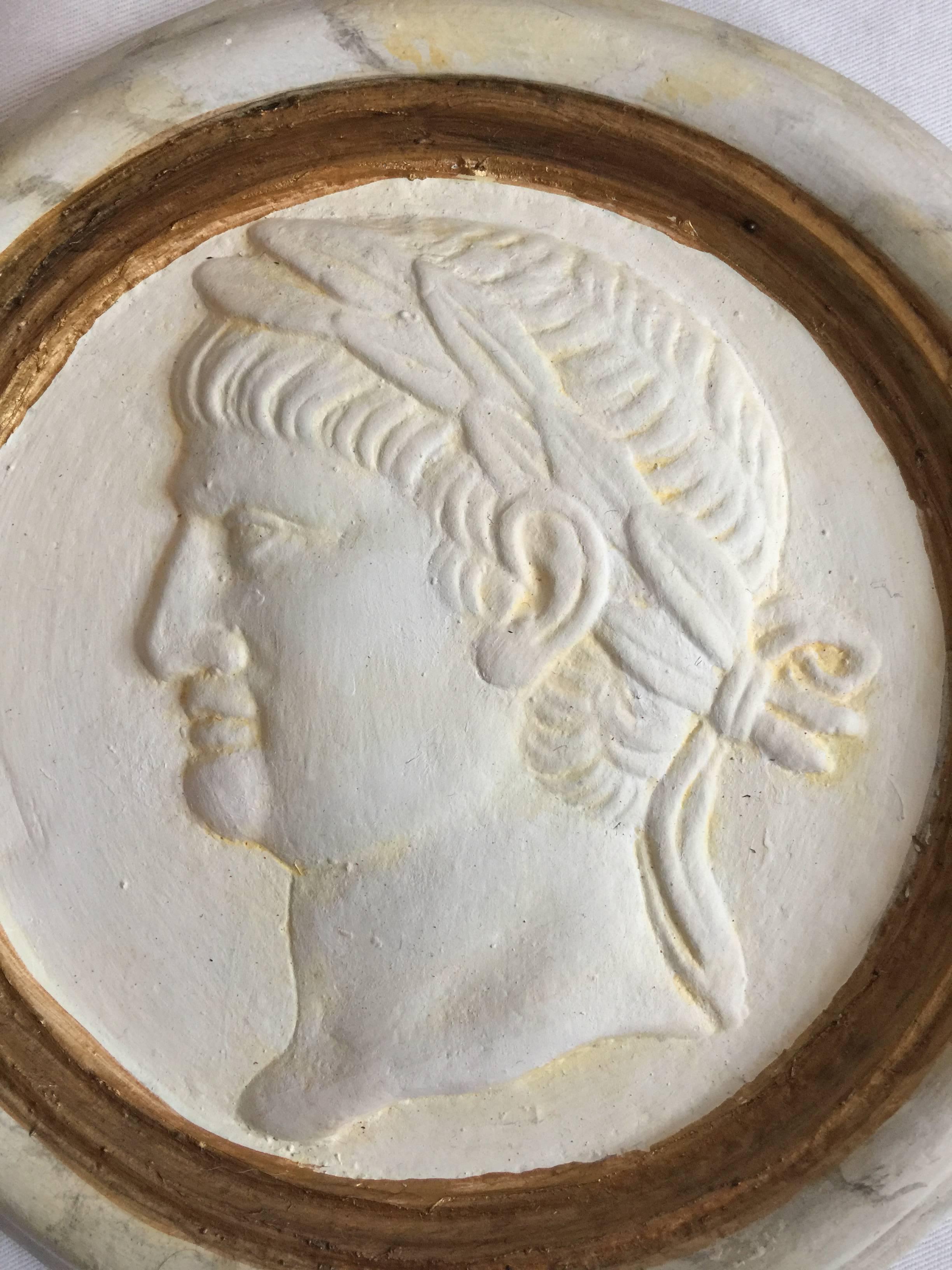 Handsome pair of Classic Roman reliefs or medallions. Marbleized detailing and painted gold finish. Cast plaster with wall hangers embedded in the material. Purchased in Rome.