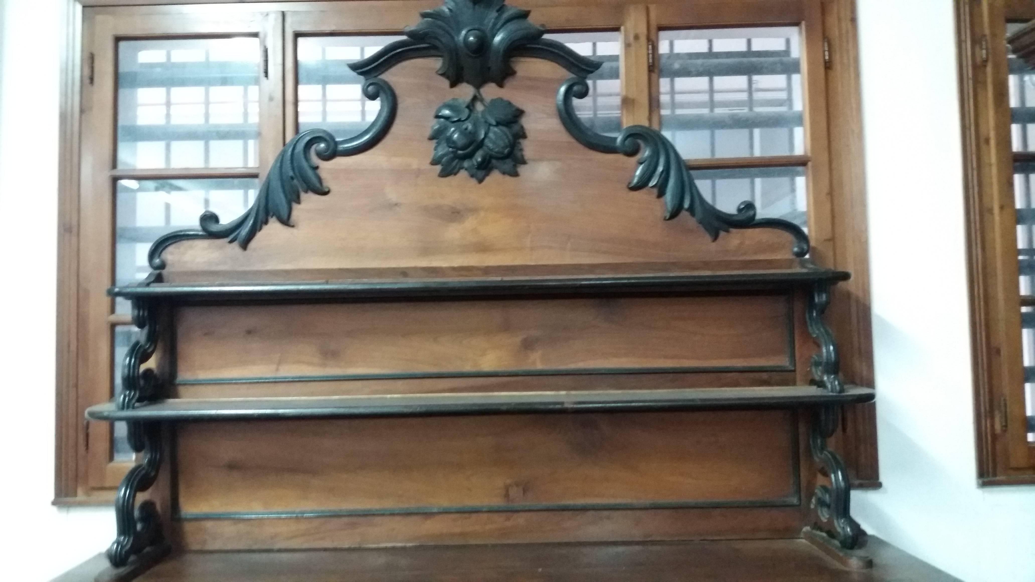 Designed to be the centerpiece of an early 19th century dining room and crafted of solid walnut and walnut root, the buffet features several elevated serving areas, including a pair of curved, locking drawers, a long upper shelf, and a strong,