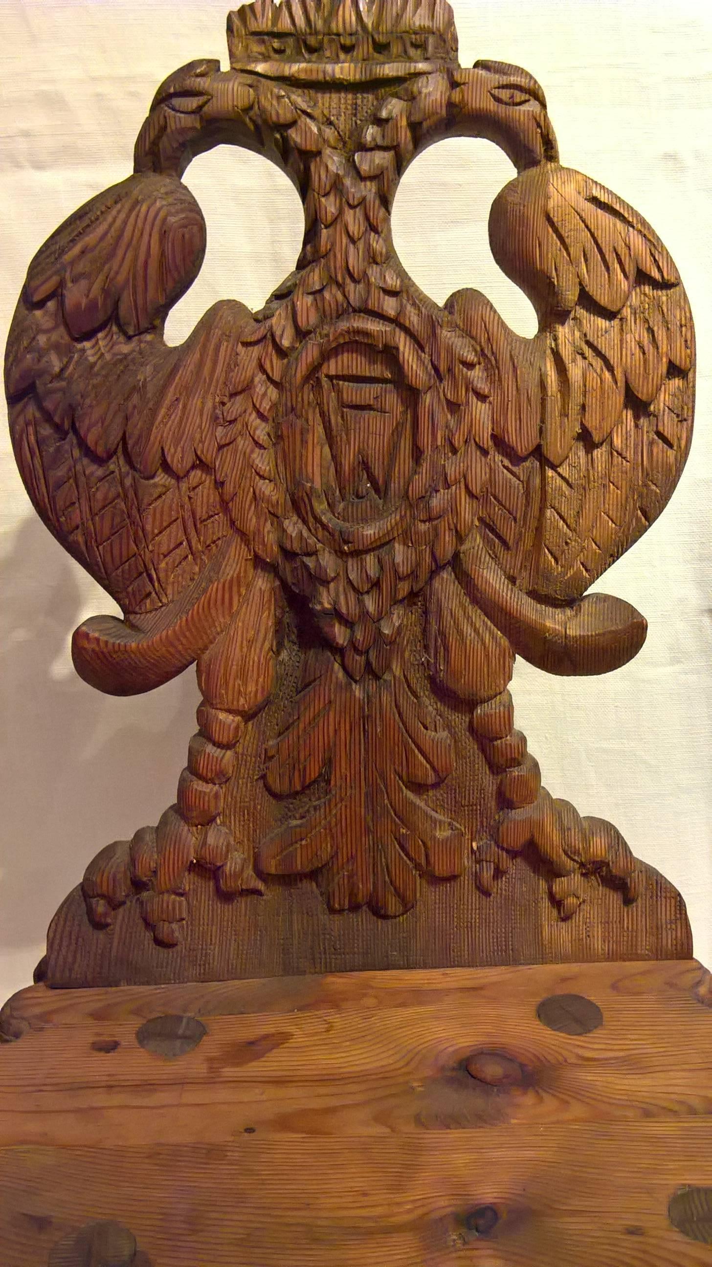 This 19th century Austrian board chair is hand-carved in solid softwood with an abundant decor. Inhabited by two eagles with eagle talons and topped with a crown. In the middle a medallion framed with leaves. In the centre of the medallion a