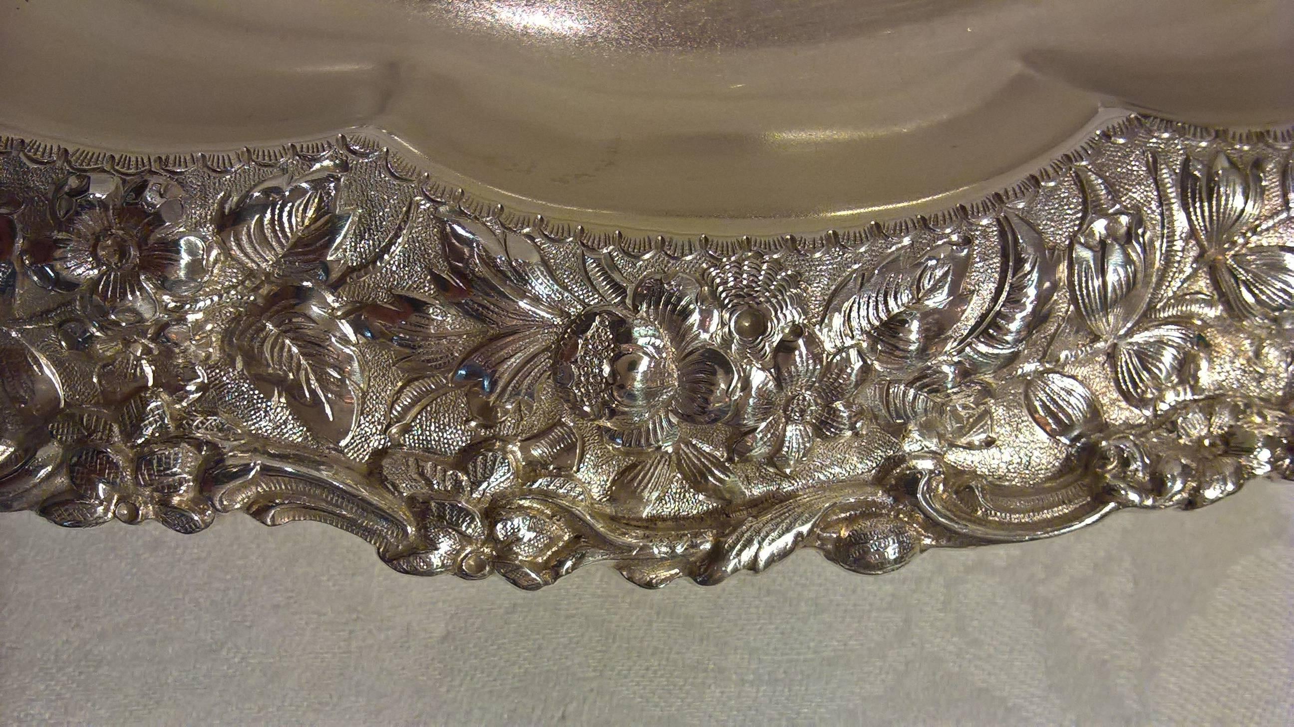 Art Nouveau sterling silver bowl with bright floral repousse. Asymmetric rim with flowers and fern leaves. Bowl rests on four scrolled paw feet. Hallmark includes pattern nr 6162 and directors letter M. Order nr 8008. Weight 610 gr. Beautiful