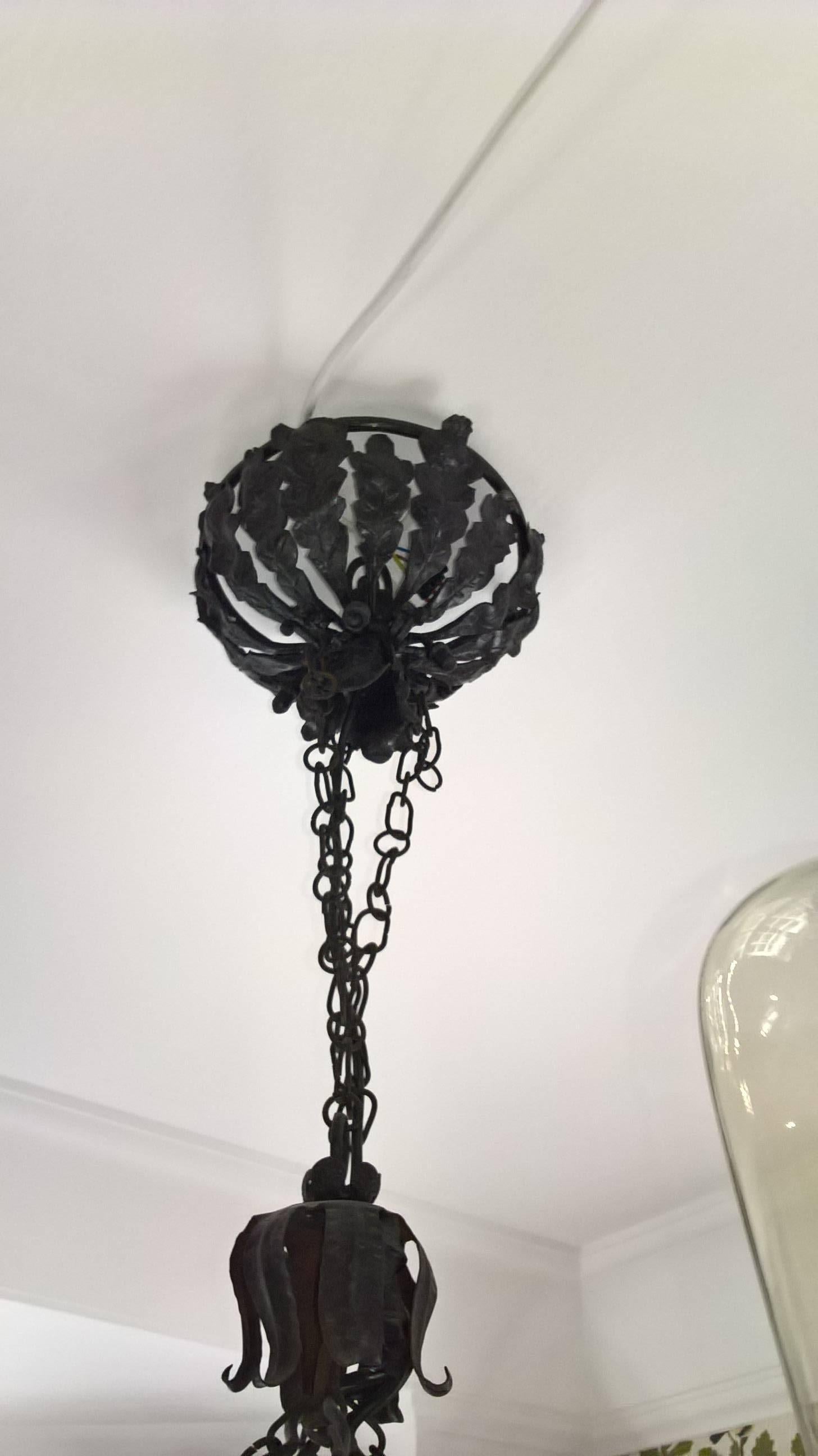 Large German mid-century  pendant  in handmade iron in black with four bulbs . Beautiful hand-crafted natural details with hearts, oaks and oak leaves. New electrification. Beautiful canopy formed by handmade iron leaves and oaks. Hanging on 4 iron