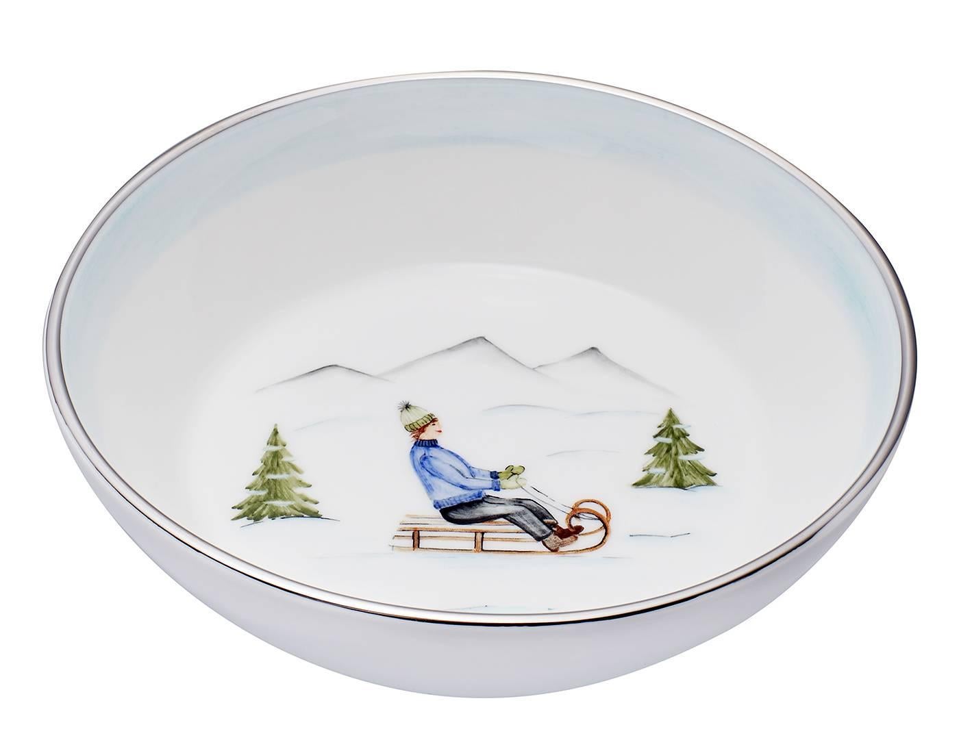 These completely handmade porcelain bowls painted with a charming hands-free winter decor come as a set of two designs. One shows a boy on a sladder and the other bowl is hands-free painted with a pair of ice skater. Rimmed with a 24 carat gold or