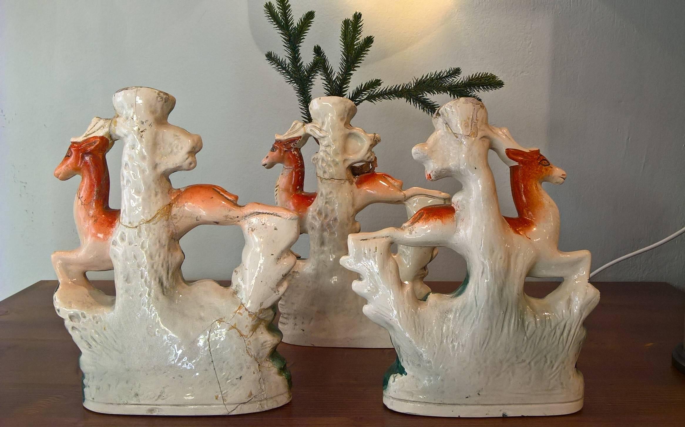 Set of three large antique 19 th century English Staffordshire pottery decorative spill vases. Modelled as deer’s colored in red-orange with white dogs springing in front of green tree-trunk forms to be used as a vase. Partly with antique gold.