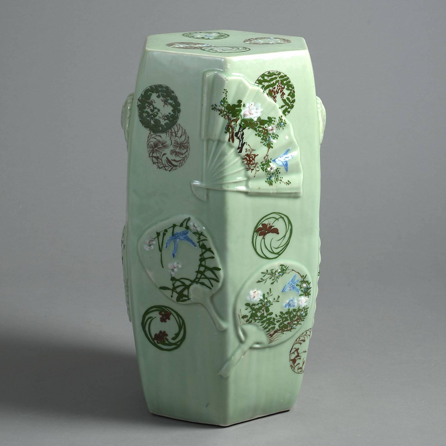 The bulbous hexagonal body moulded in relief with fans decorated with birds and cherry blossom on a celadon green glazed ground and with pierced and moulded handles to each side.

Perfect for use in the garden or as a small table next to a sofa or