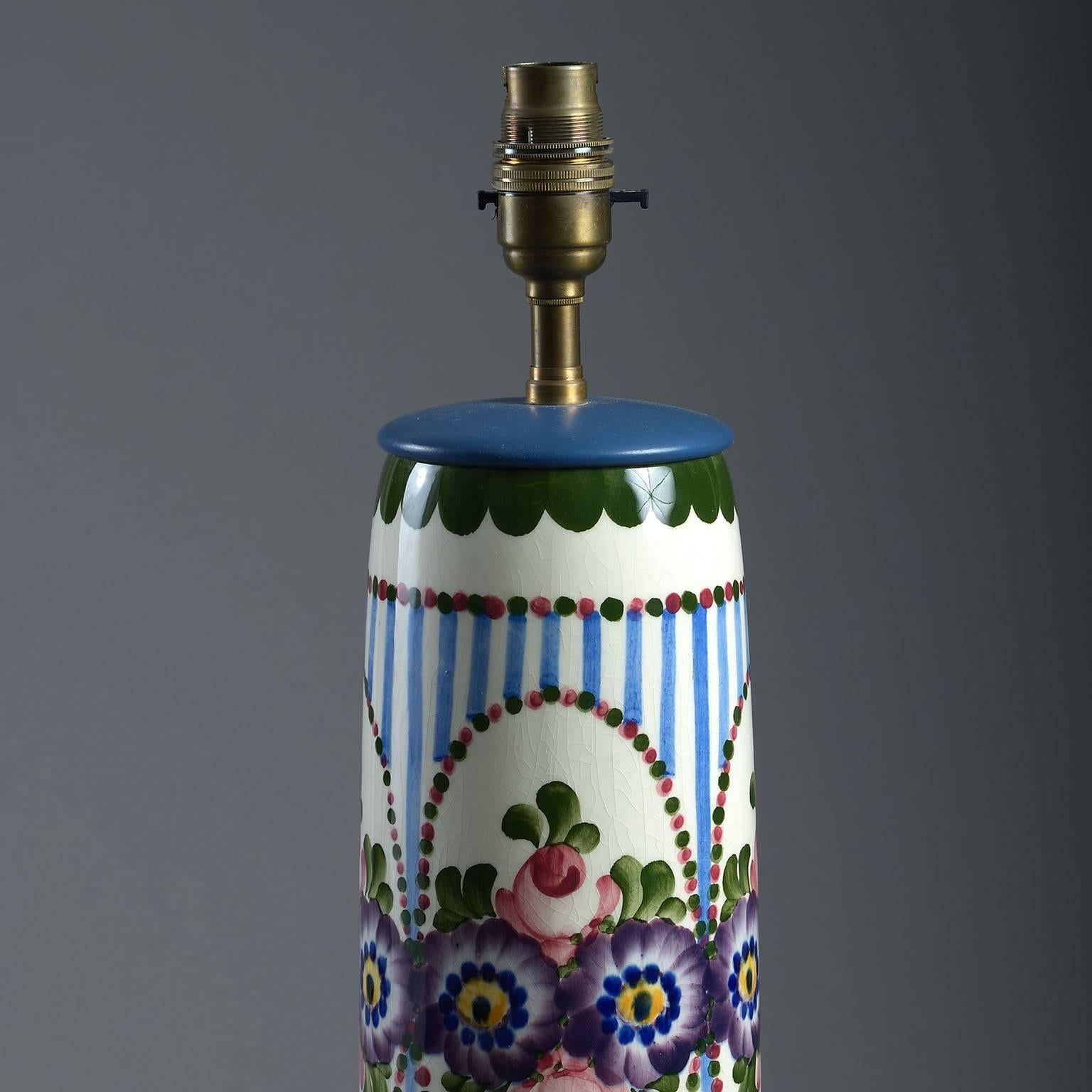 The baluster body hand-decorated in the style of Wemyss-ware, inscribed Dec 510, underglaze on base. Mounted with blue-painted cover and base with silk-covered, braided cable.
 