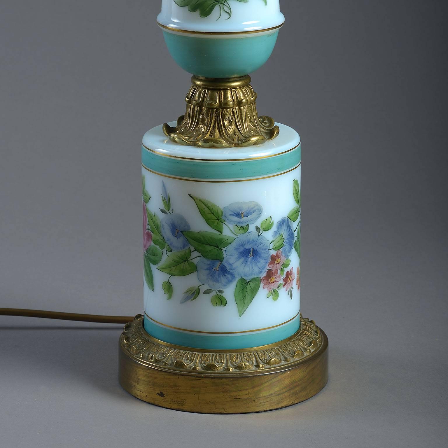 The opaline glass baluster column and base painted with summer flowers on a milk-white ground within turquoise bands with chased gilt-brass mounts.
 
