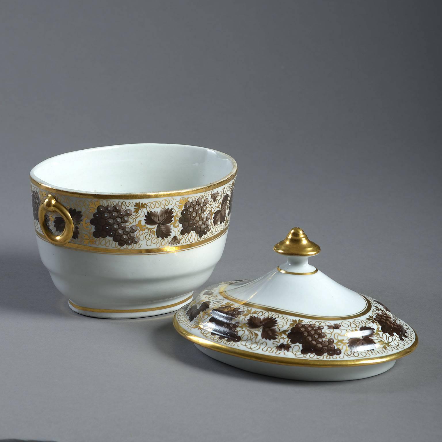 The oval body with moulded ring handles decorated with fruiting vines in puce and gilt. The base with incised 