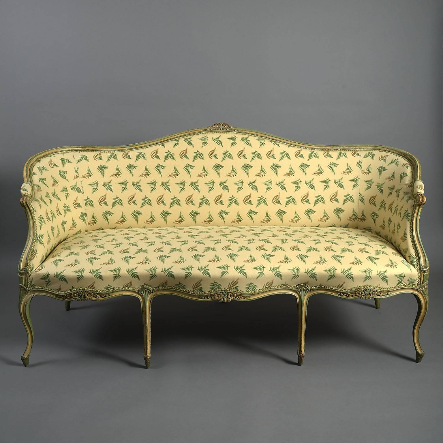 18th century English George III painted sofa.
In the French taste, the moulded beechwood frame carved with flowers to the cresting and seat rails. The serpentine form raised on cabriole legs all painted in palest yellow picked out in green. The
