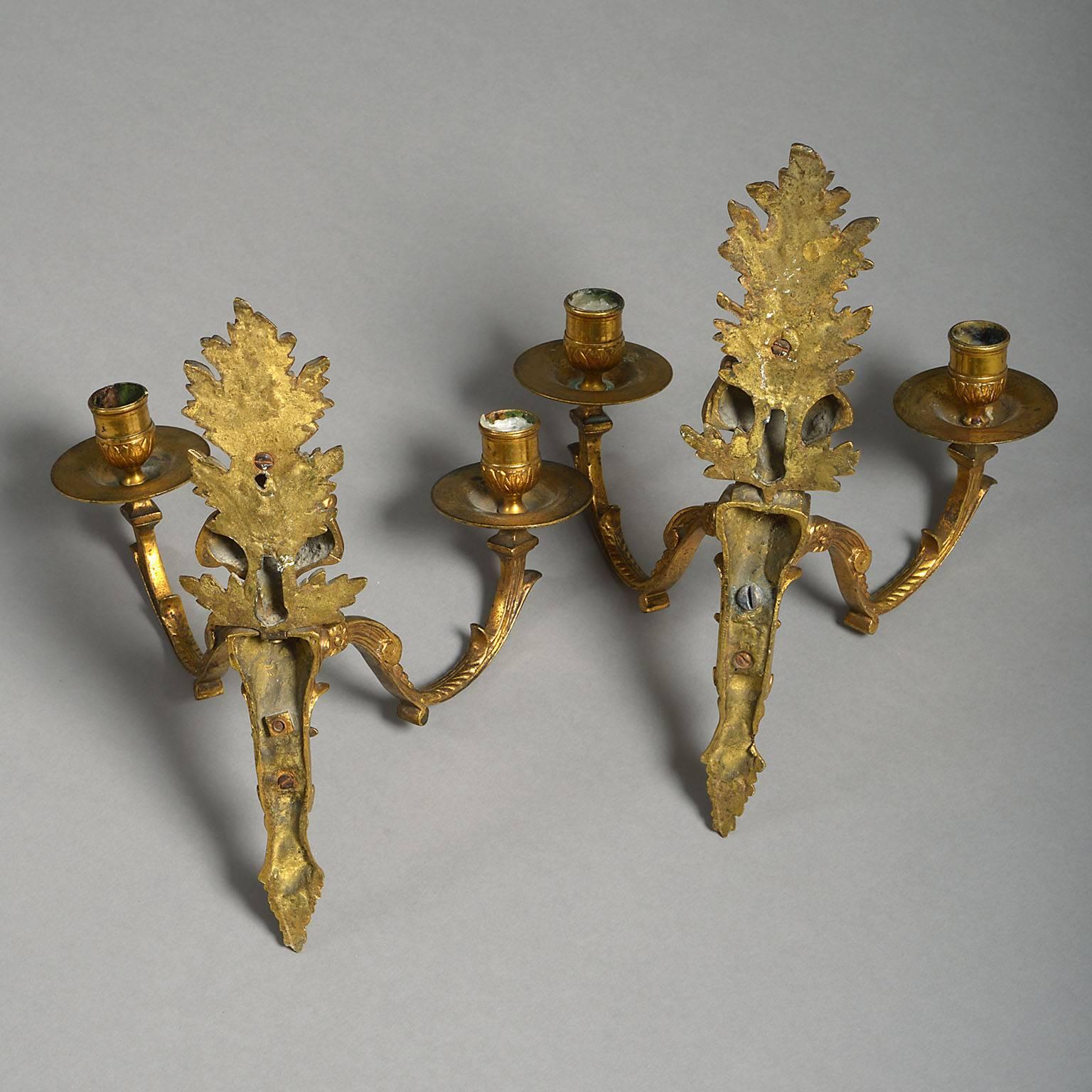 Rare pair of early 18th century Louis XIV gilt-brass wall-lights
The gilt brass backplates formed of tapering pedestals surmounted by opposing busts with foliate surrounds and supporting two candle-branches.

French, circa 1710.

Measures: