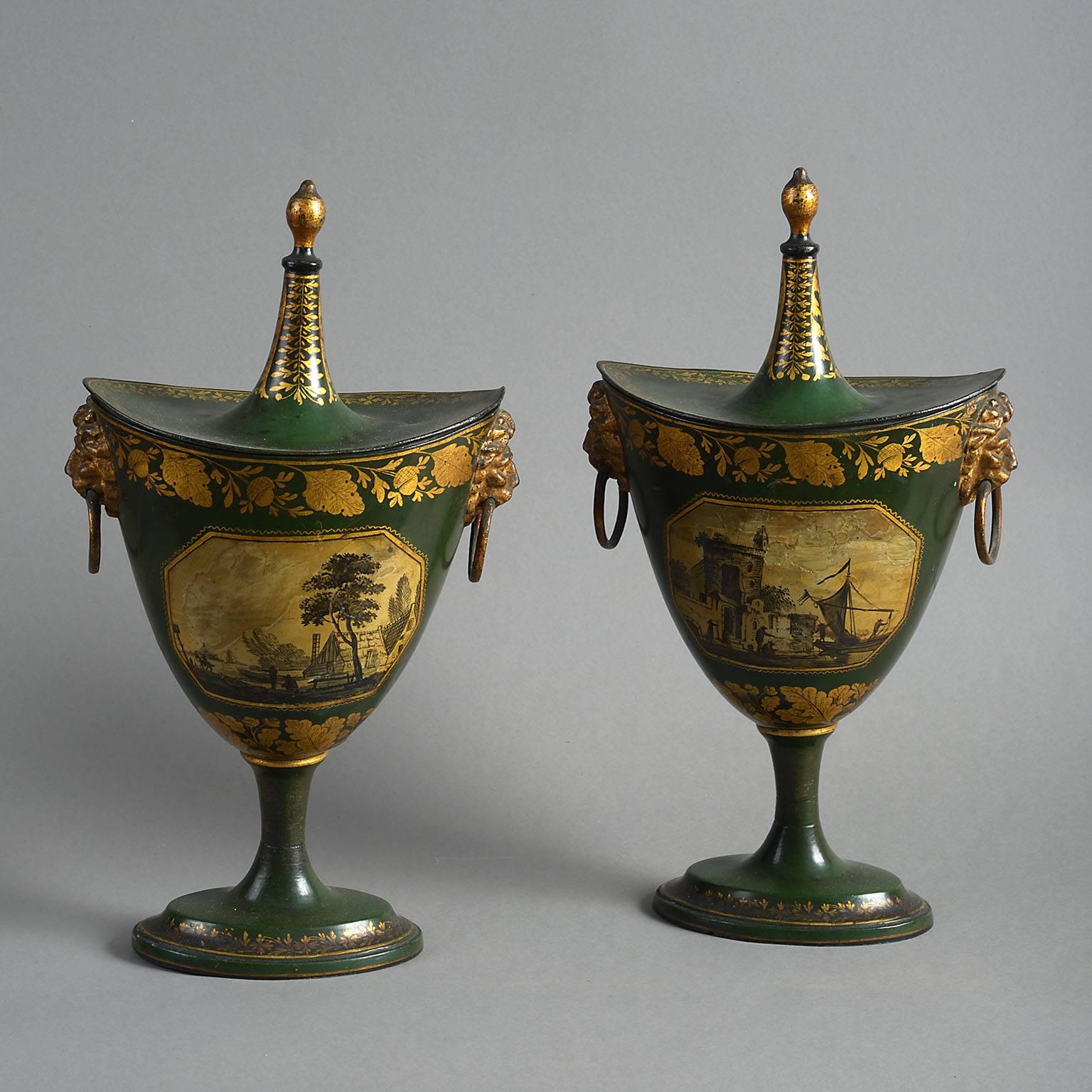 The navicular form urns below removable tented covers and raised on waisted pedestals and with lions mask handles. Finely decorated with gilt oak leaves and acorns on a dark green ground and with opposing panels on each side painted with a cottage