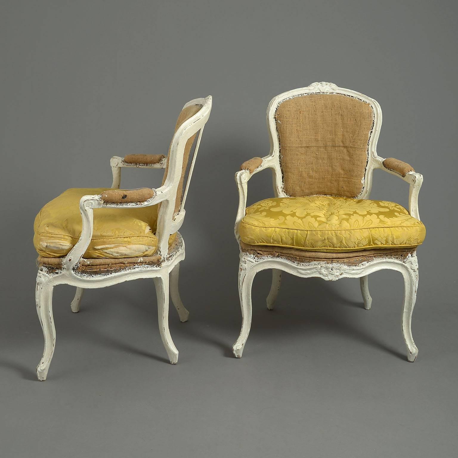 The white-painted moulded frames with cartouche shaped backs carved with floral decoration and with loose-cushioned seats raised on cabriole legs.
 