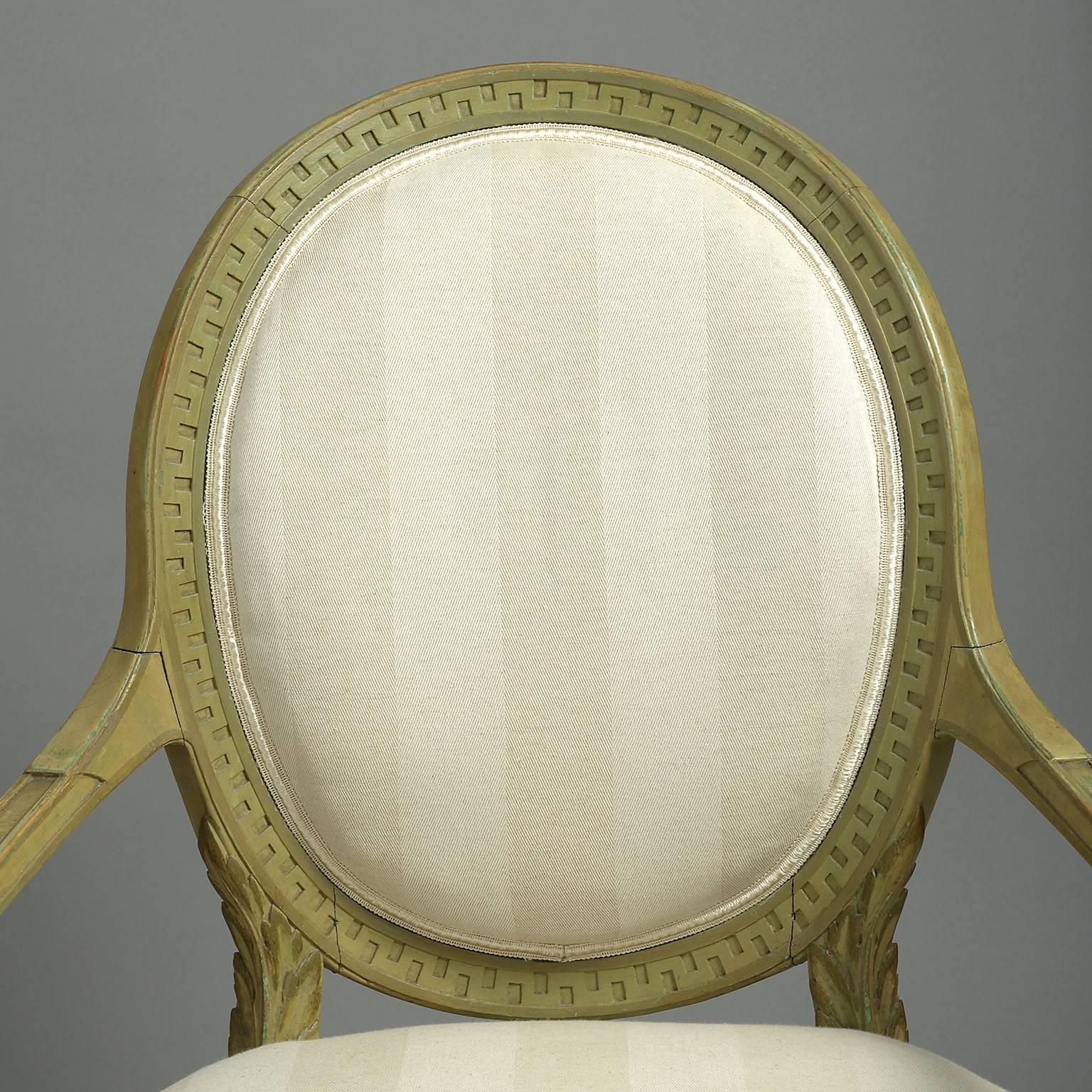 The oval backs with Greek key carved decoration, out-swept arms with acanthus leaf carved front supports in the neoclassical taste.
Traditionally upholstered sprung seat covered in a neutral, striped cream colored herringbone linen raised on square