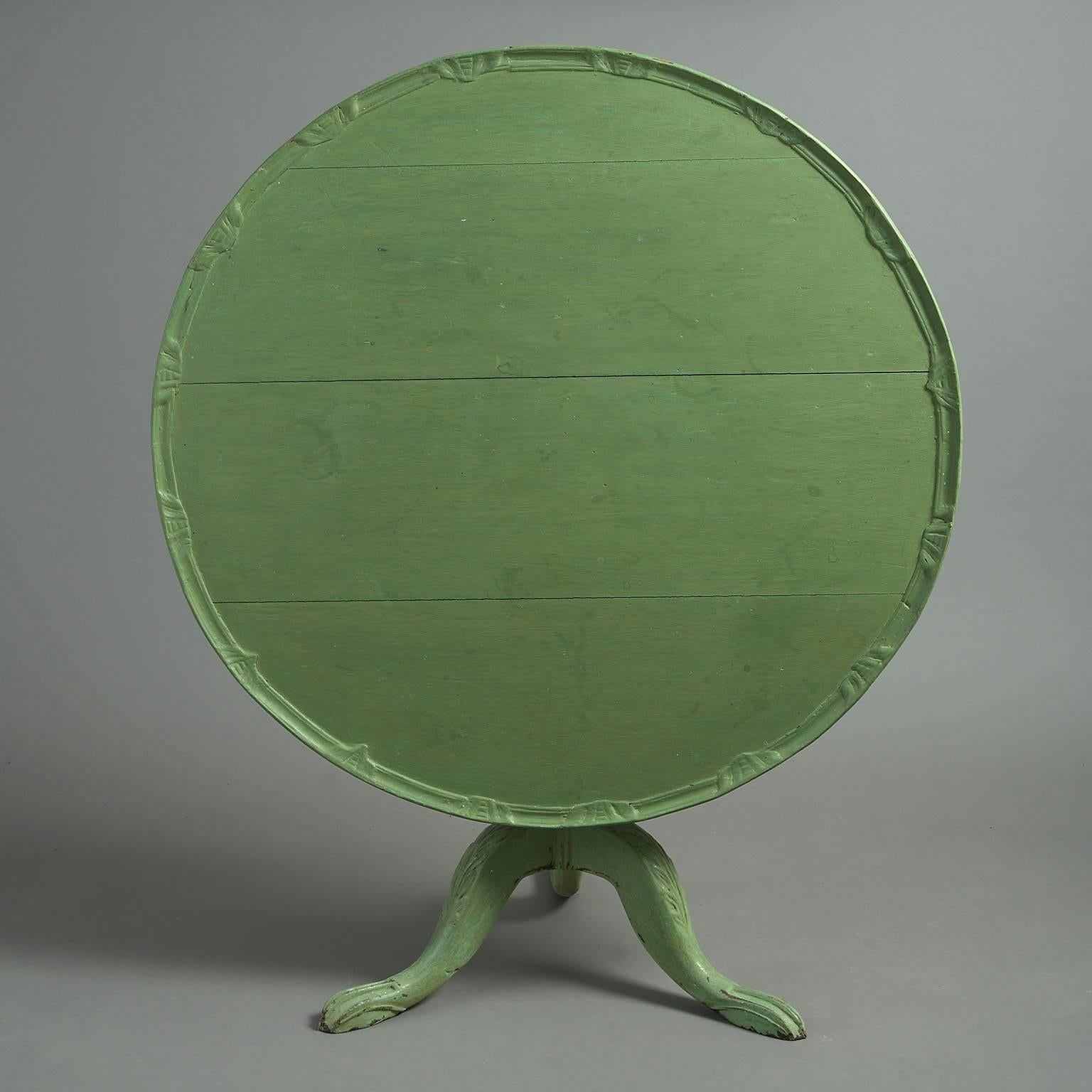The circular plank top with carved raised border, on a birdcage support allowing the top to rotate 360 degrees with fluted central column and leaf-carved cabriole legs; painted decoration refreshed.


 