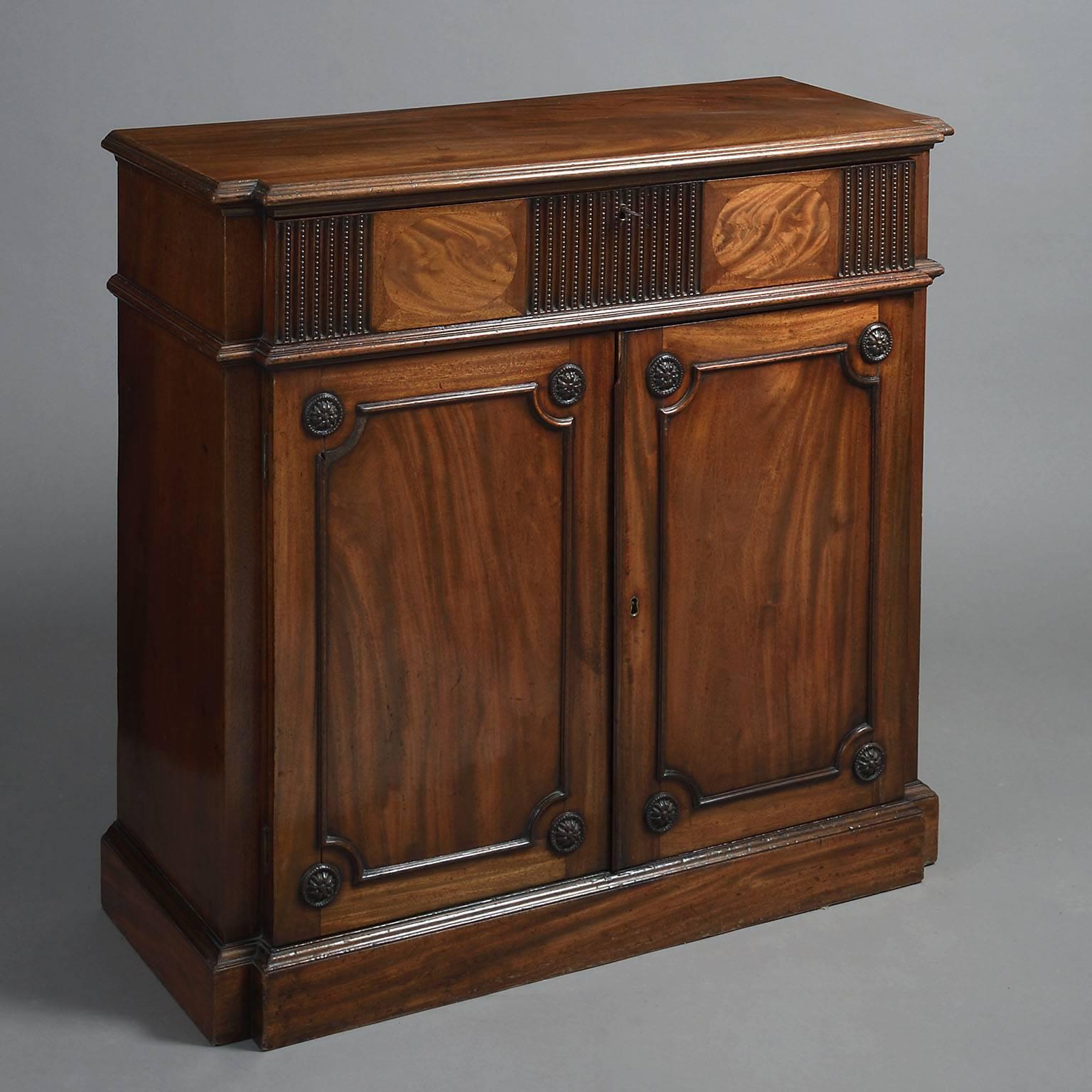 Almost certainly from the workshop of Thomas Chippendale. The breakfront rectangular moulded top above a secretaire drawer inlaid with oval flame panels, flutes and beads; above a pair of moulded panelled doors with foliate roundels to each corner,
