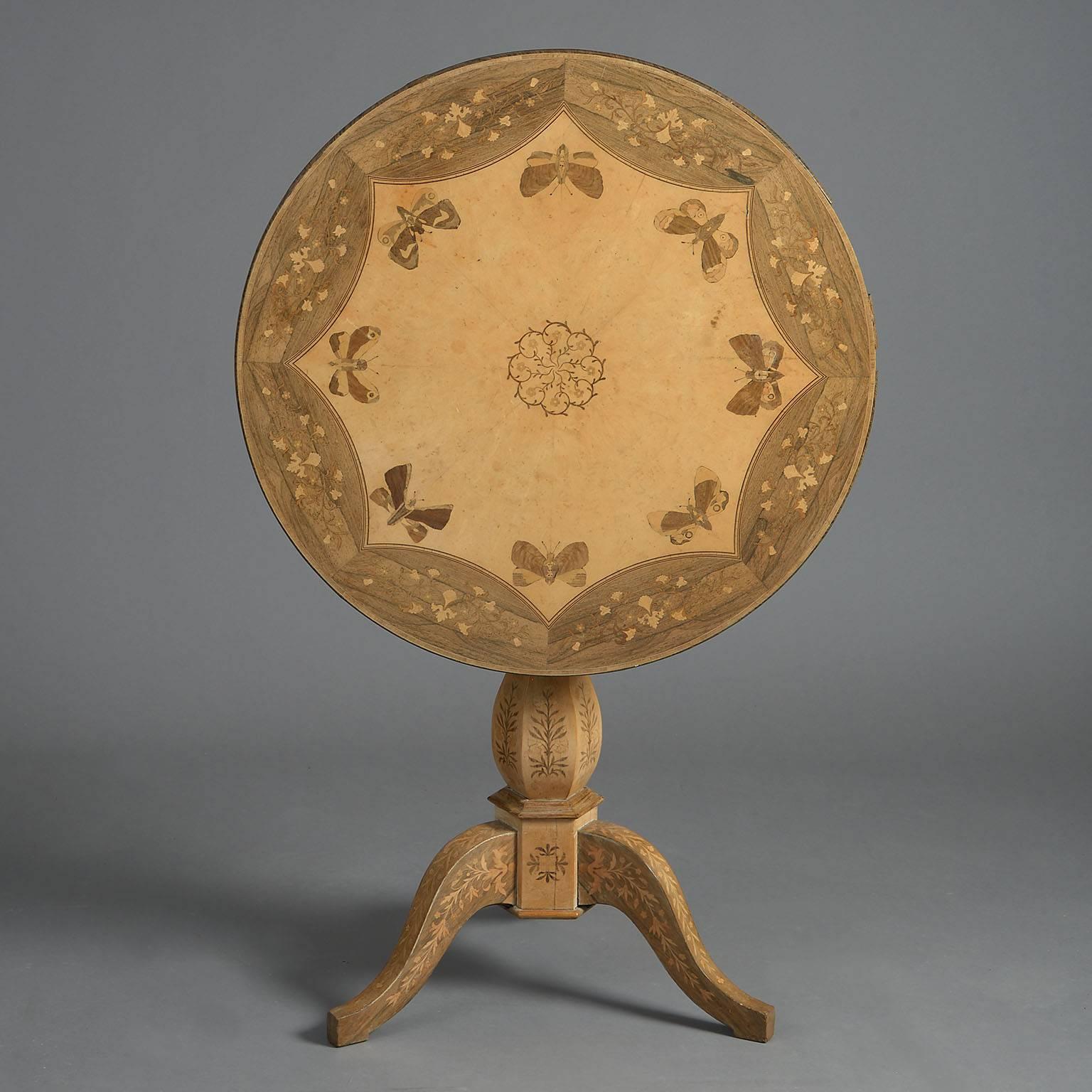 The circular top inlaid with butterflies and stylized foliage in Rosewood and other timbers on a bird's-eye maple ground and raised on a similarly-inlaid faceted baluster stem and tripod legs.

Despite it's tantalizing inscription, neither this