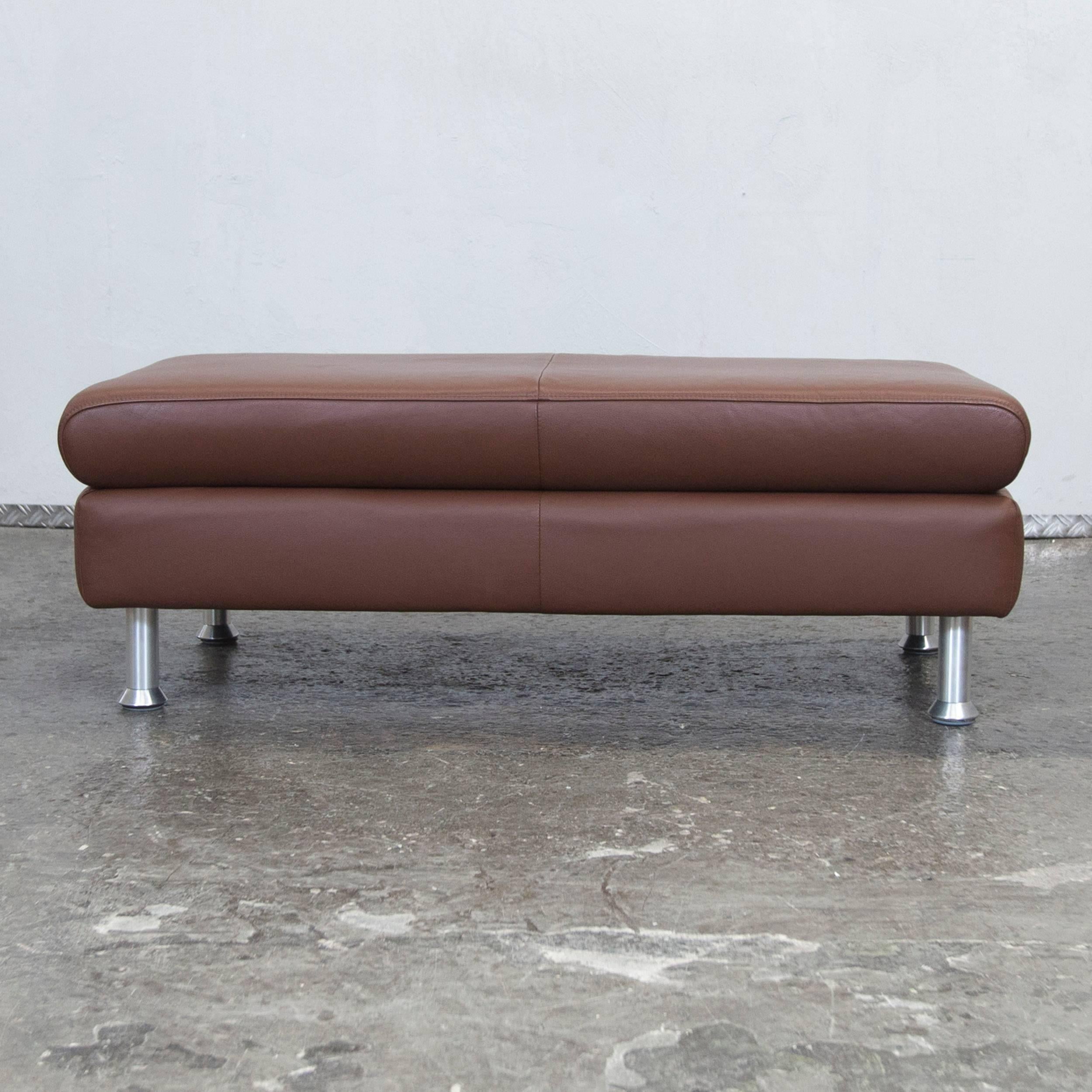 Brown colored designer leather footstool in a modern and minimalistic style, designed for flexible placing and pure comfort.
