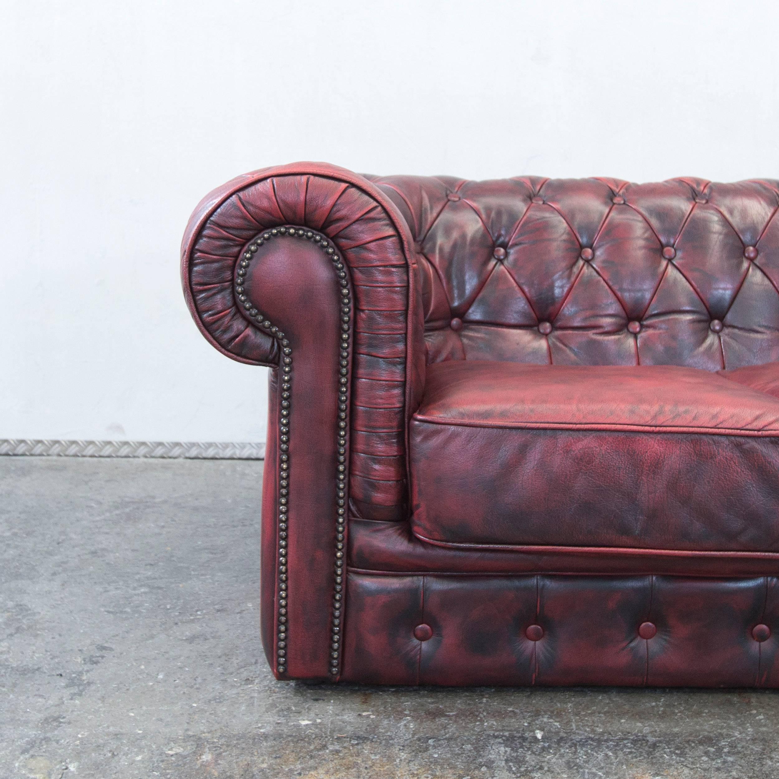 Red colored Chesterfield designer leather sofa in a vintage style, designed for pure comfort.