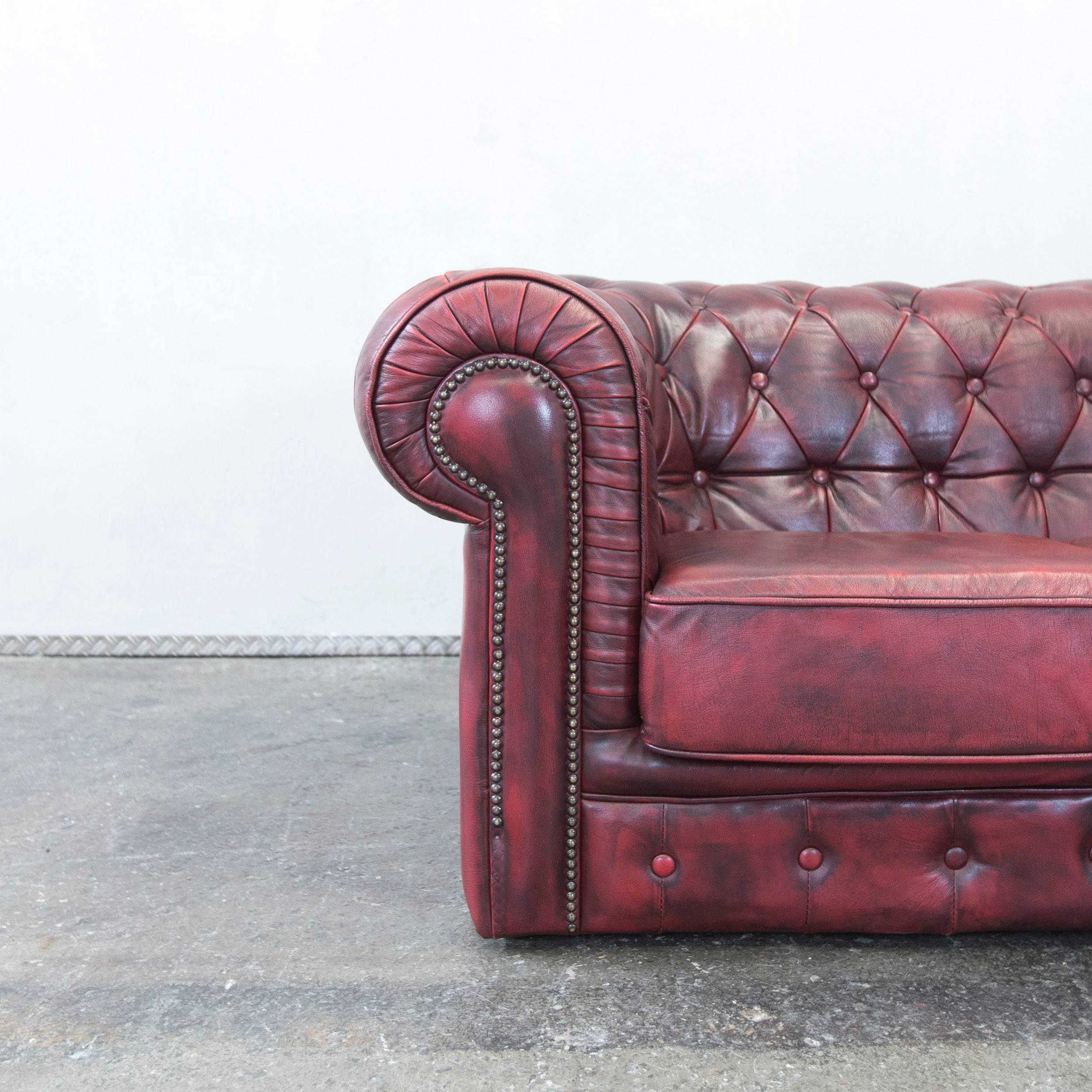Red colored Chesterfield designer leather sofa in a vintage style, designed for pure comfort.