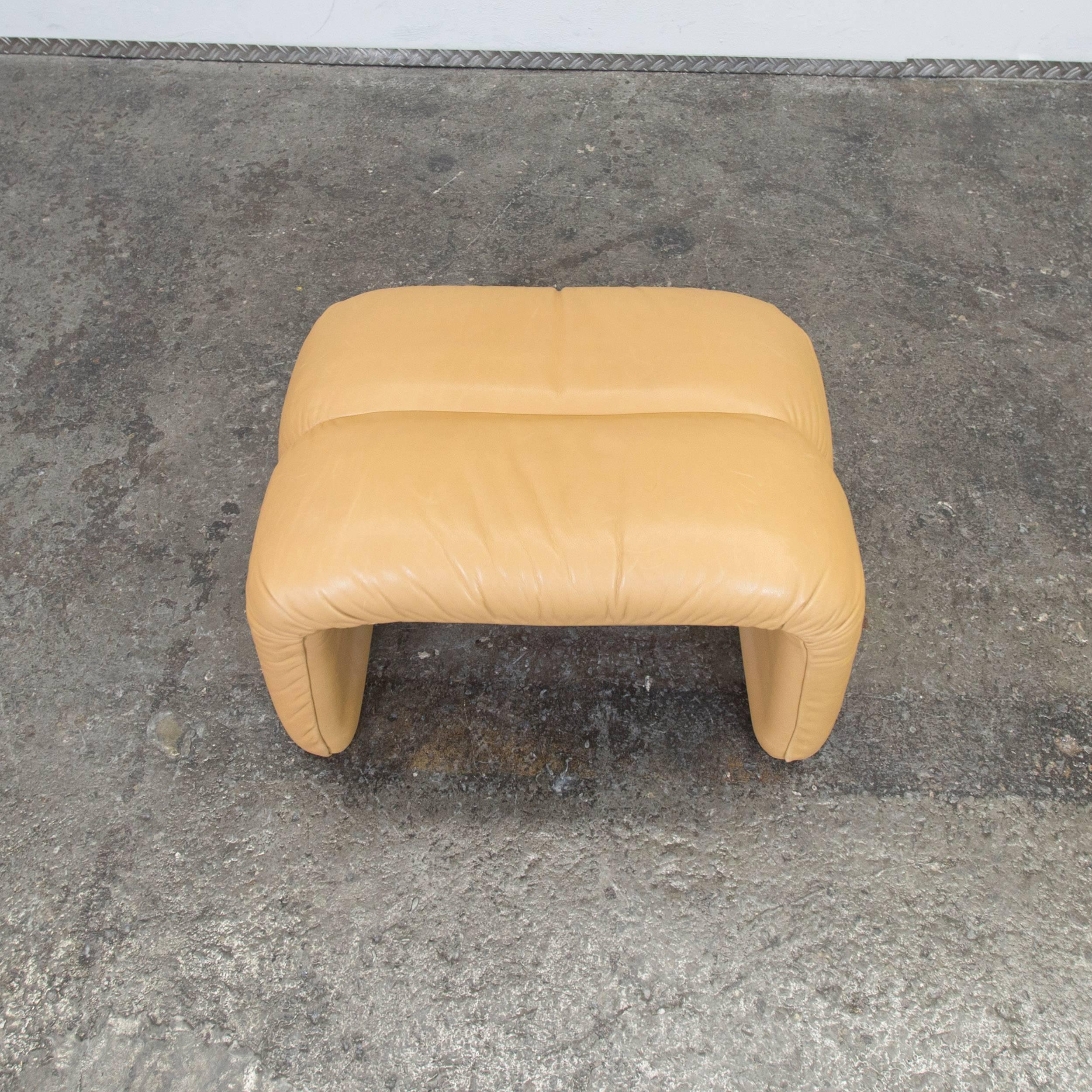 Brown colored original COR designer leather footstool in a vintage style, designed for pure comfort and flexible placing.