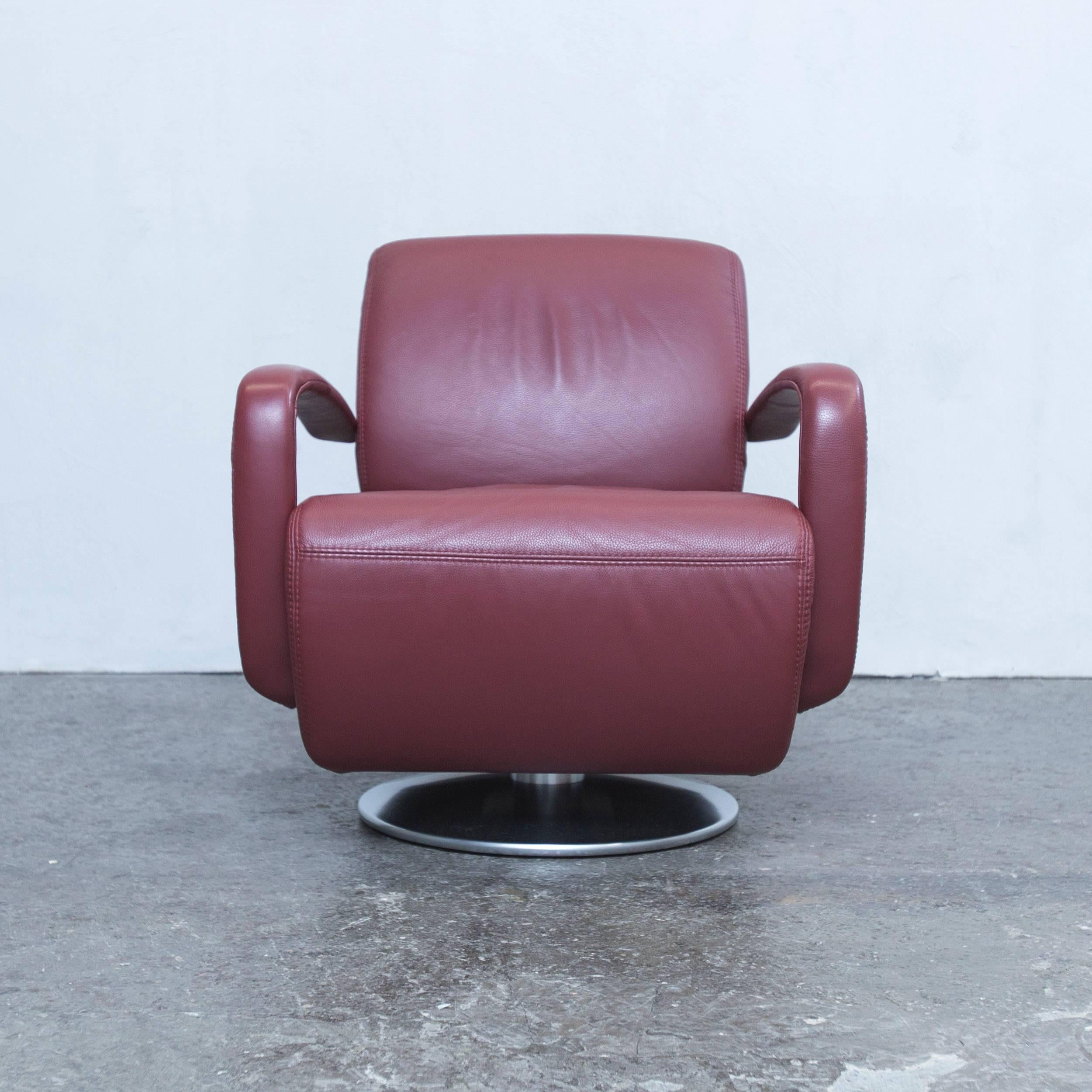 Red colored designer leather armchair in a modern and minimalistic style, designed for pure comfort and flexible placing.