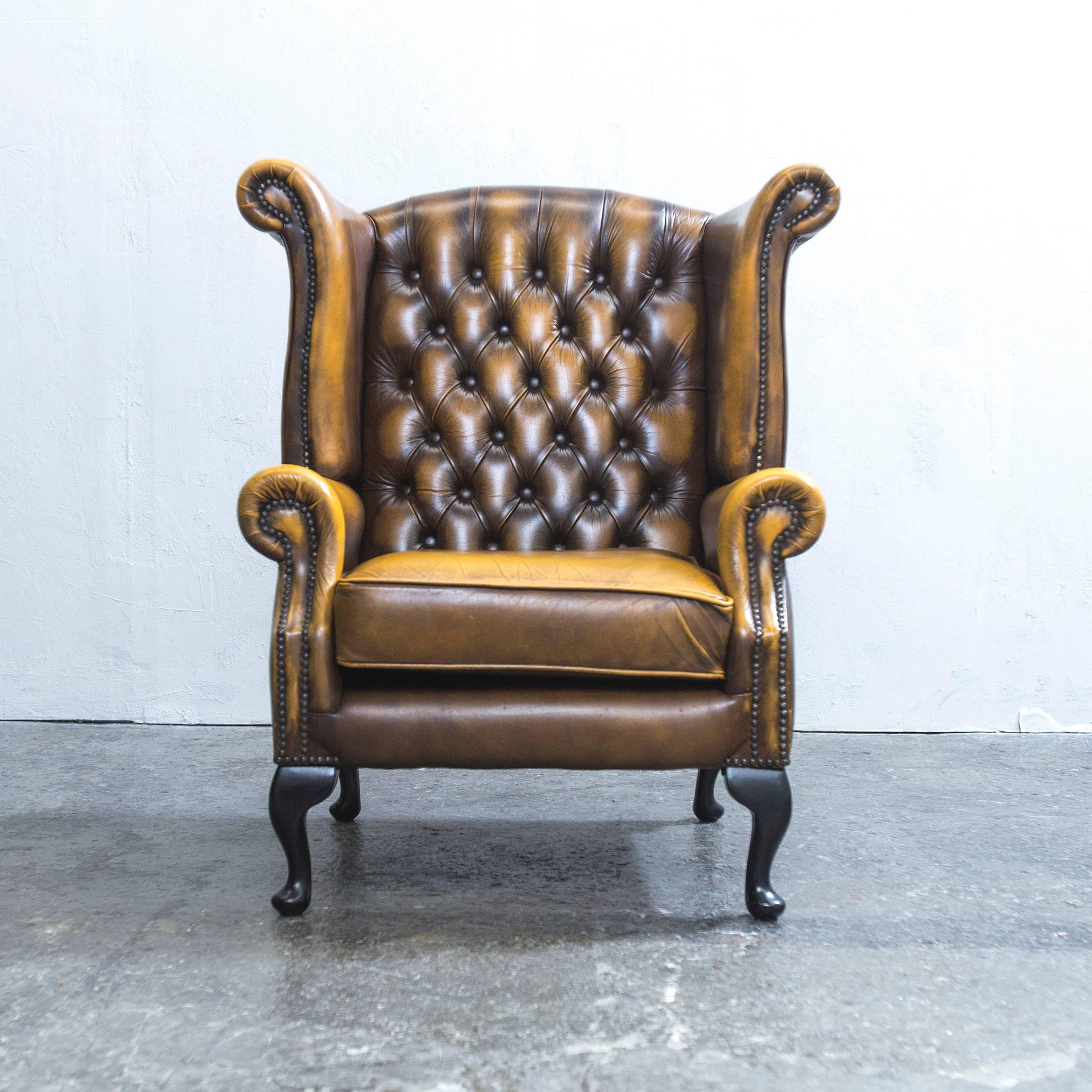 Ocher brown colored Chesterfield leather wingchair in a vintage design, made for pure comfort and elegance.