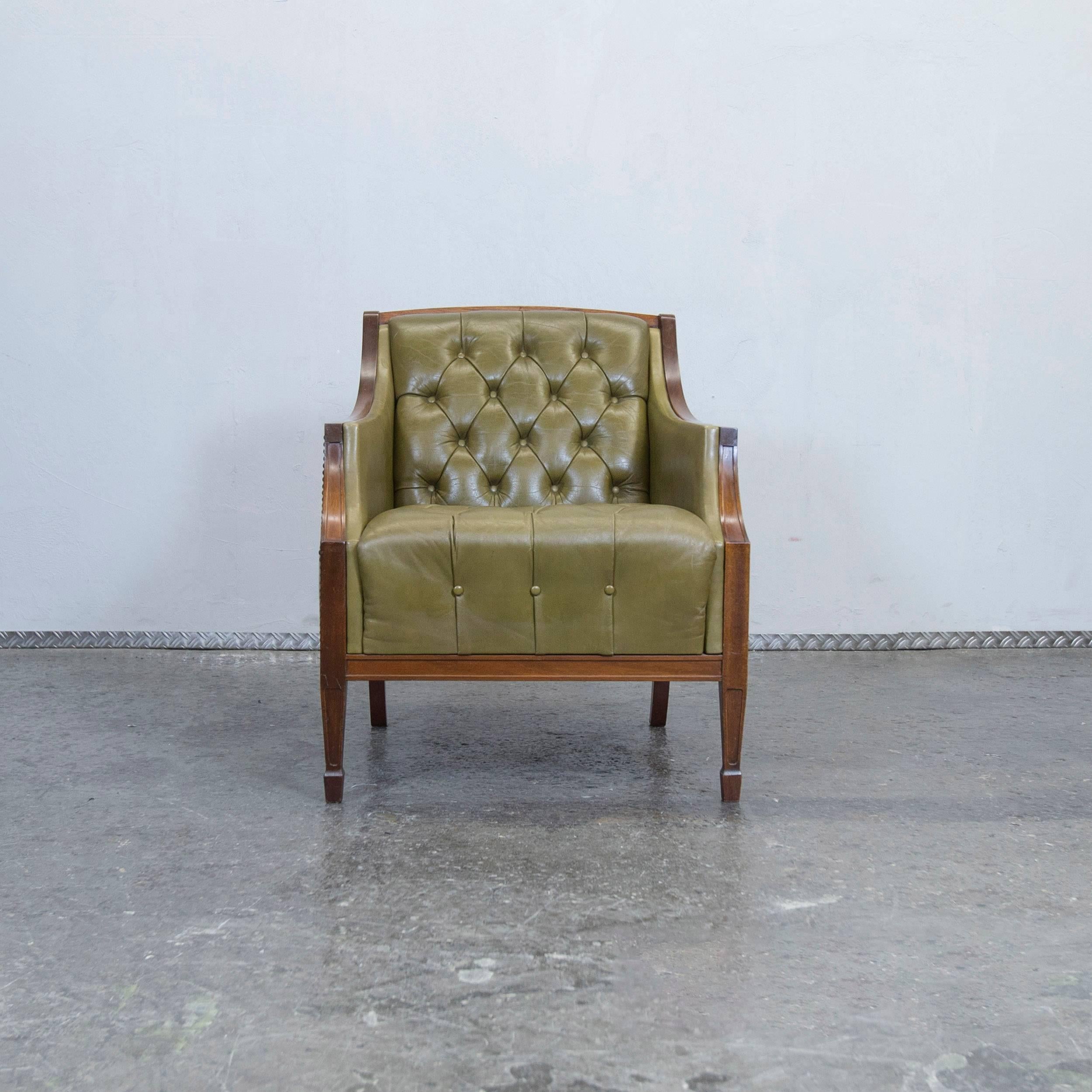 Green colored original Chesterfield leather armchair in a vintage design, made for pure comfort and elegance.