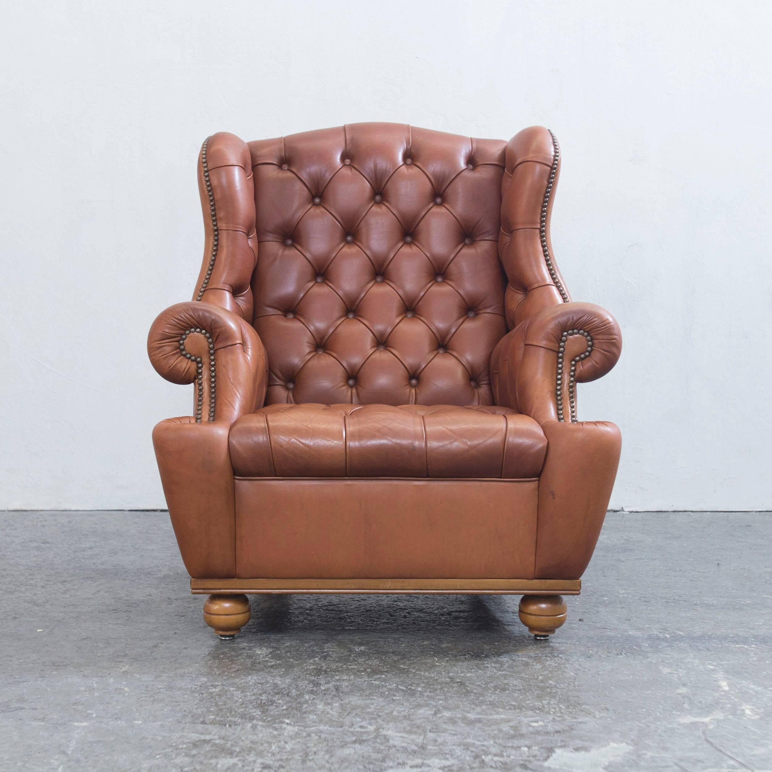 Brown colored original Chesterfield leather wingback chair in a vintage design, made for pure comfort and elegance.